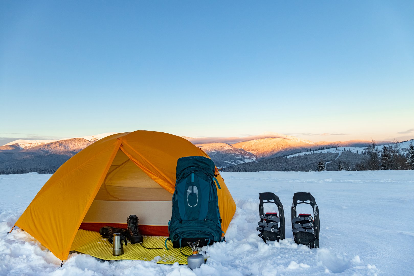 Hiking in the mountains with snowshoes, a backpack and a tent, hiking equipment.