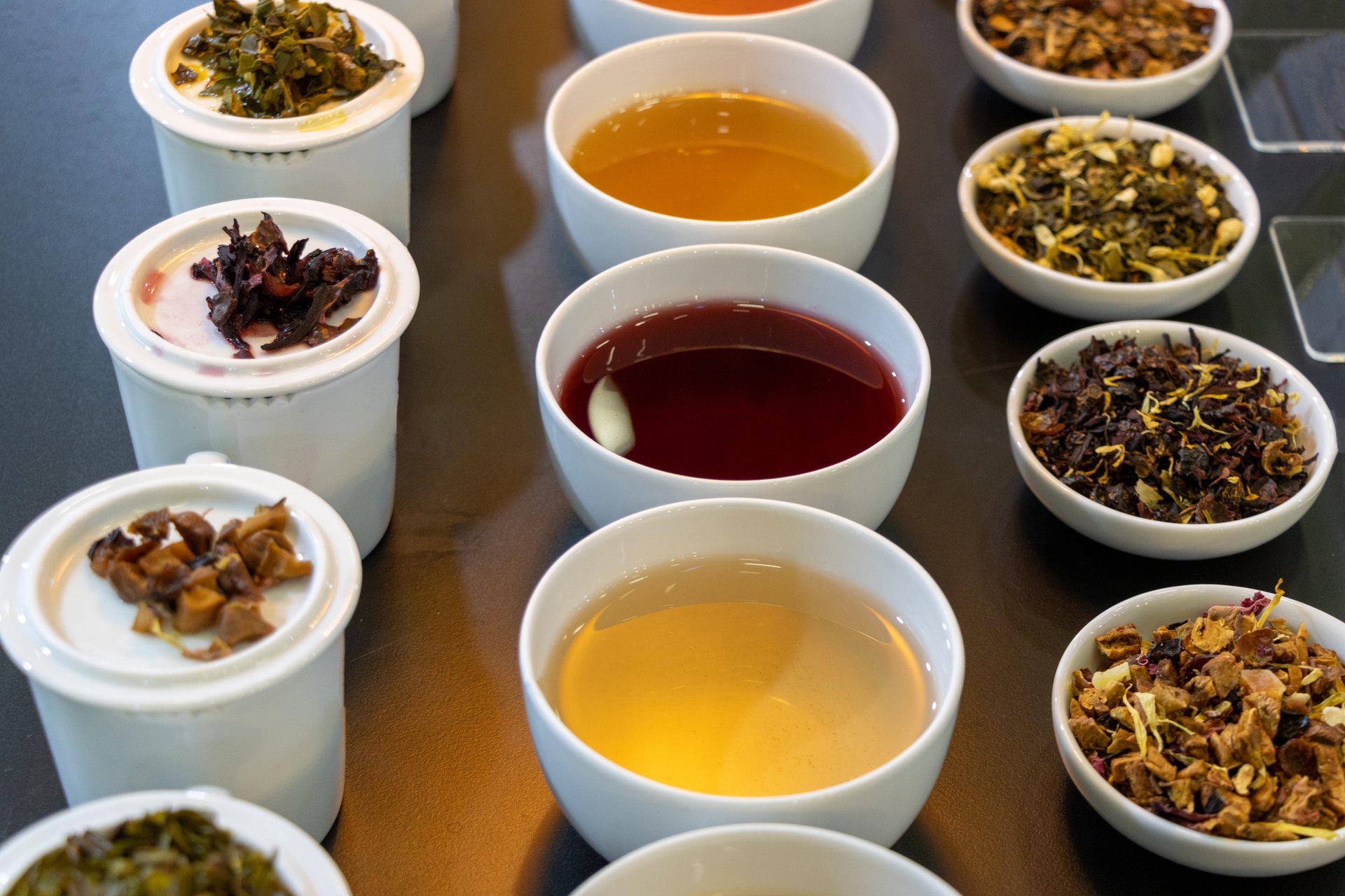 Various herbal teas in porcelain cups and bowls