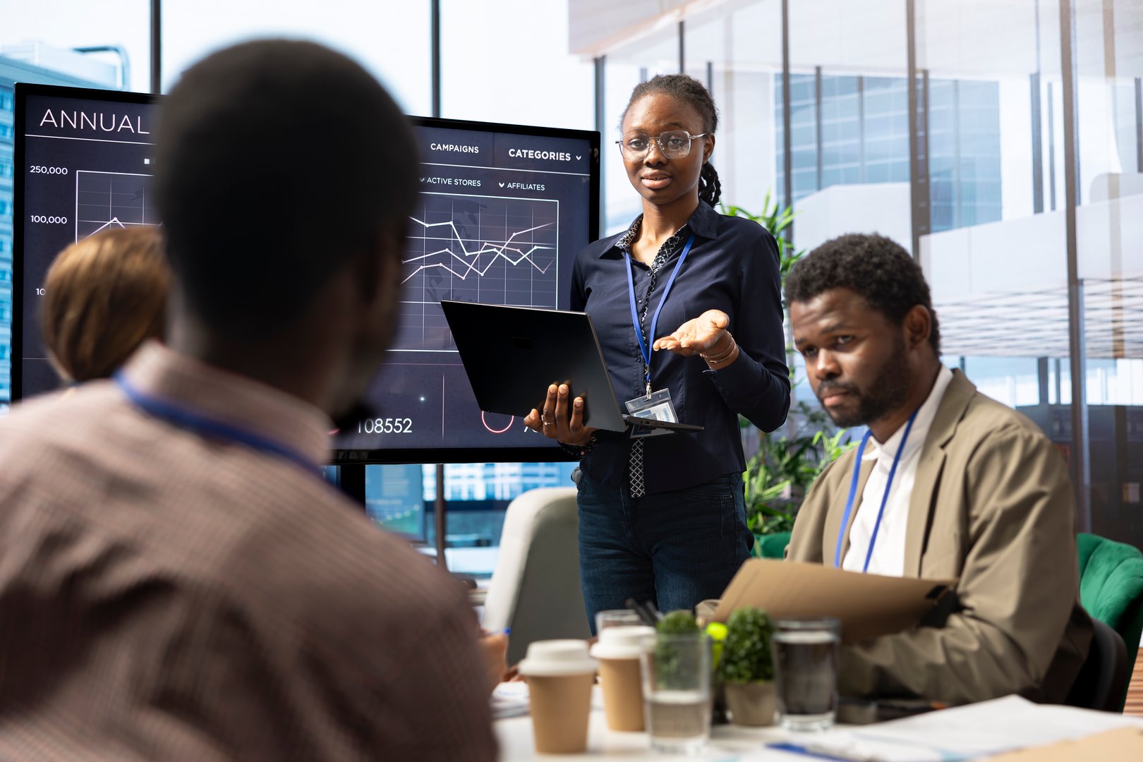 Diverse group of business professionals meeting to strategize on digital marketing initiatives, analyzing data infographics to work on global expansion. Staff ensuring organizational growth.