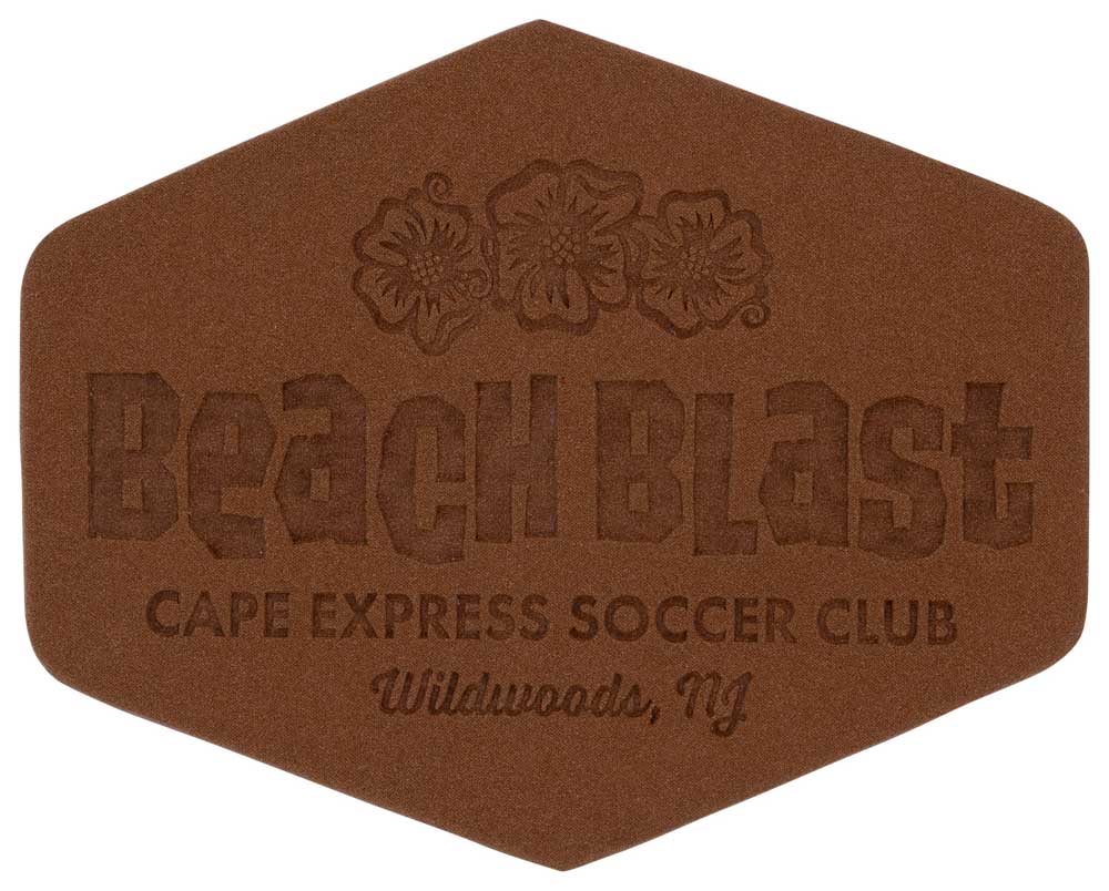A brown sand sculpture with text: Beach Blast, Cape Express Soccer Club, Wildwoods, NJ, decorated with hibiscus flowers.