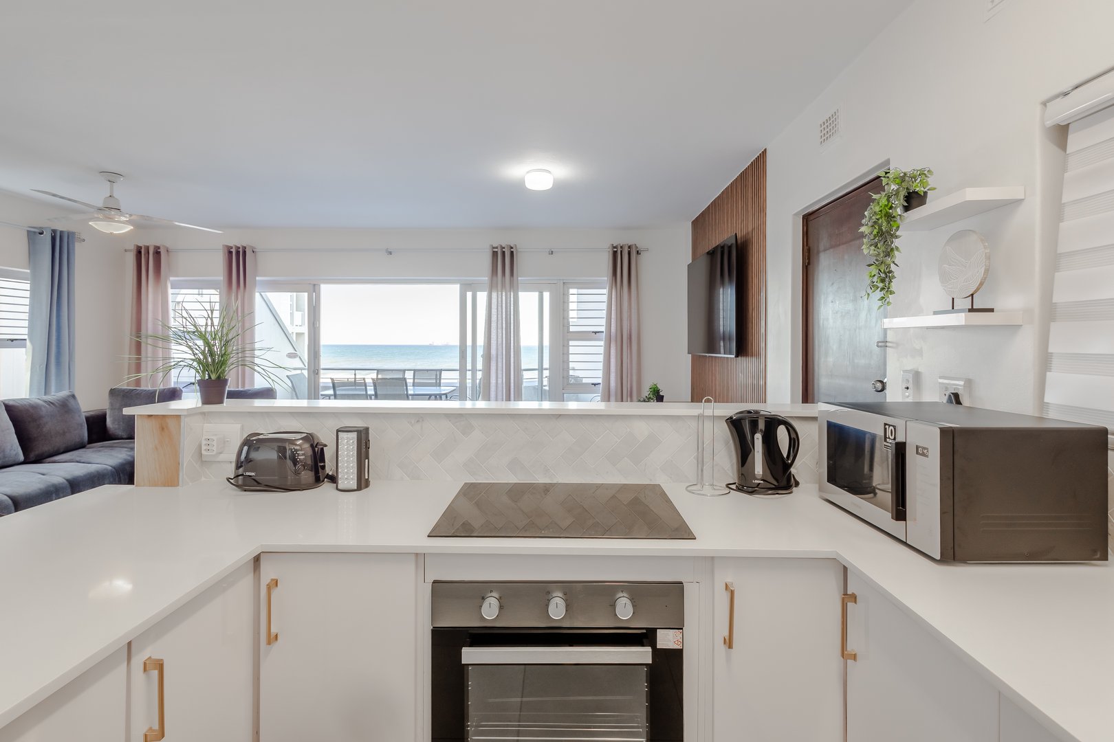 Bedroom with large bed, green throw, floral pillows, two wooden nightstands, lamps, and a floral painting above the headboard.
