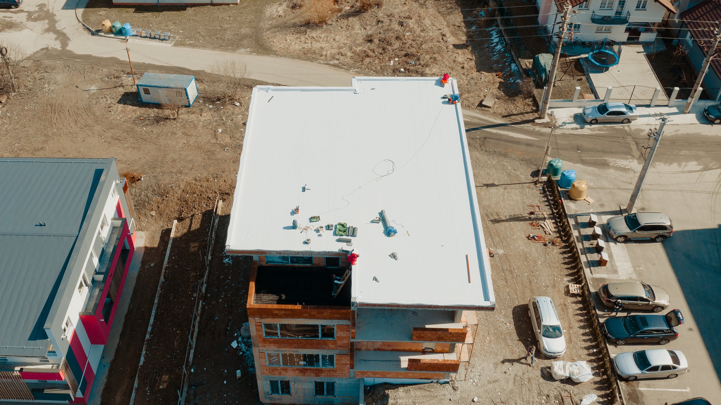 Aerial view of an apartment building with flat roof in construction, ballasted system with geotextile, PVC or EPDM membrane
