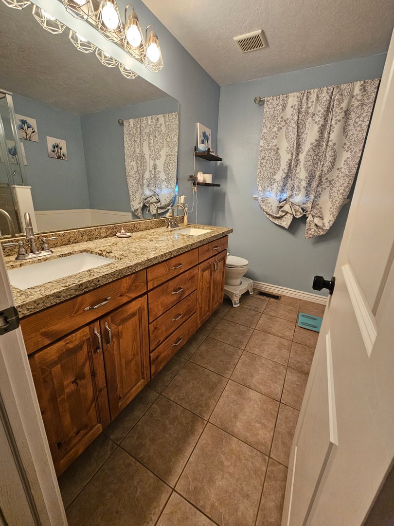 Before photo of bathroom with dark granite countertops and chrome fixtures