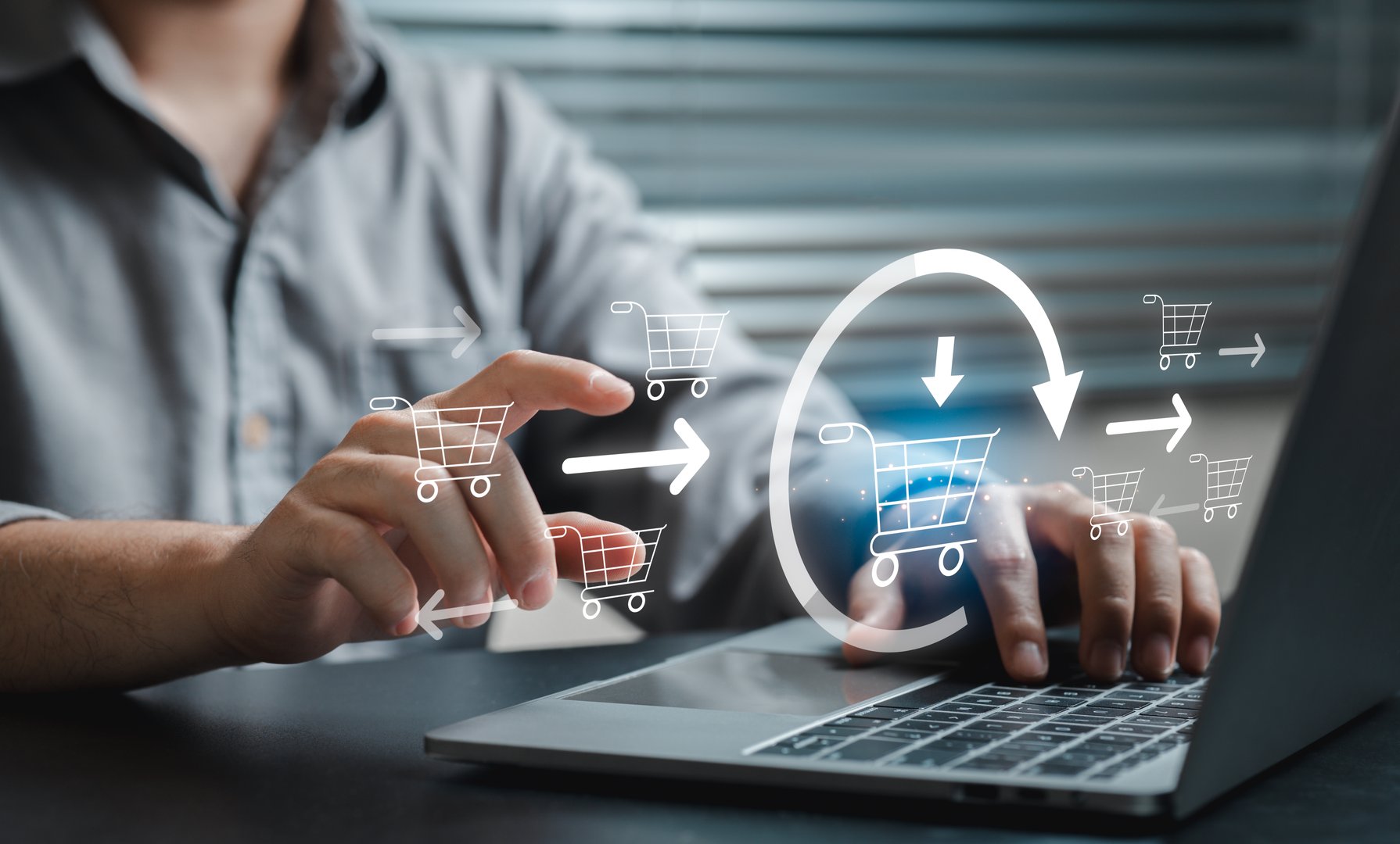 A person operates a laptop with an interface showing shopping cart icons, highlighting the modern ecommerce experience and engaging with digital retail concepts.