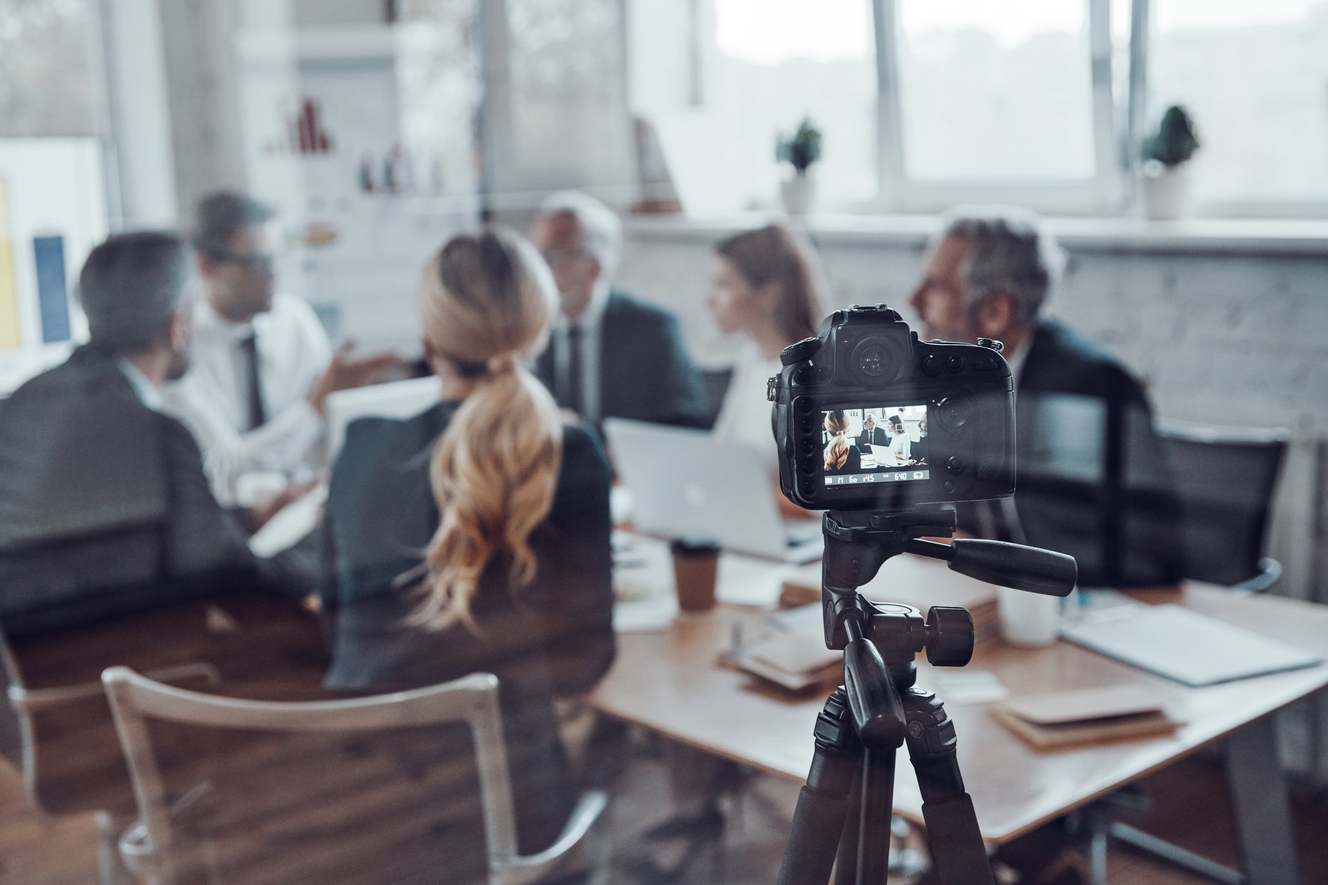 Successful business team discussing strategy while filming staff meeting in the board room