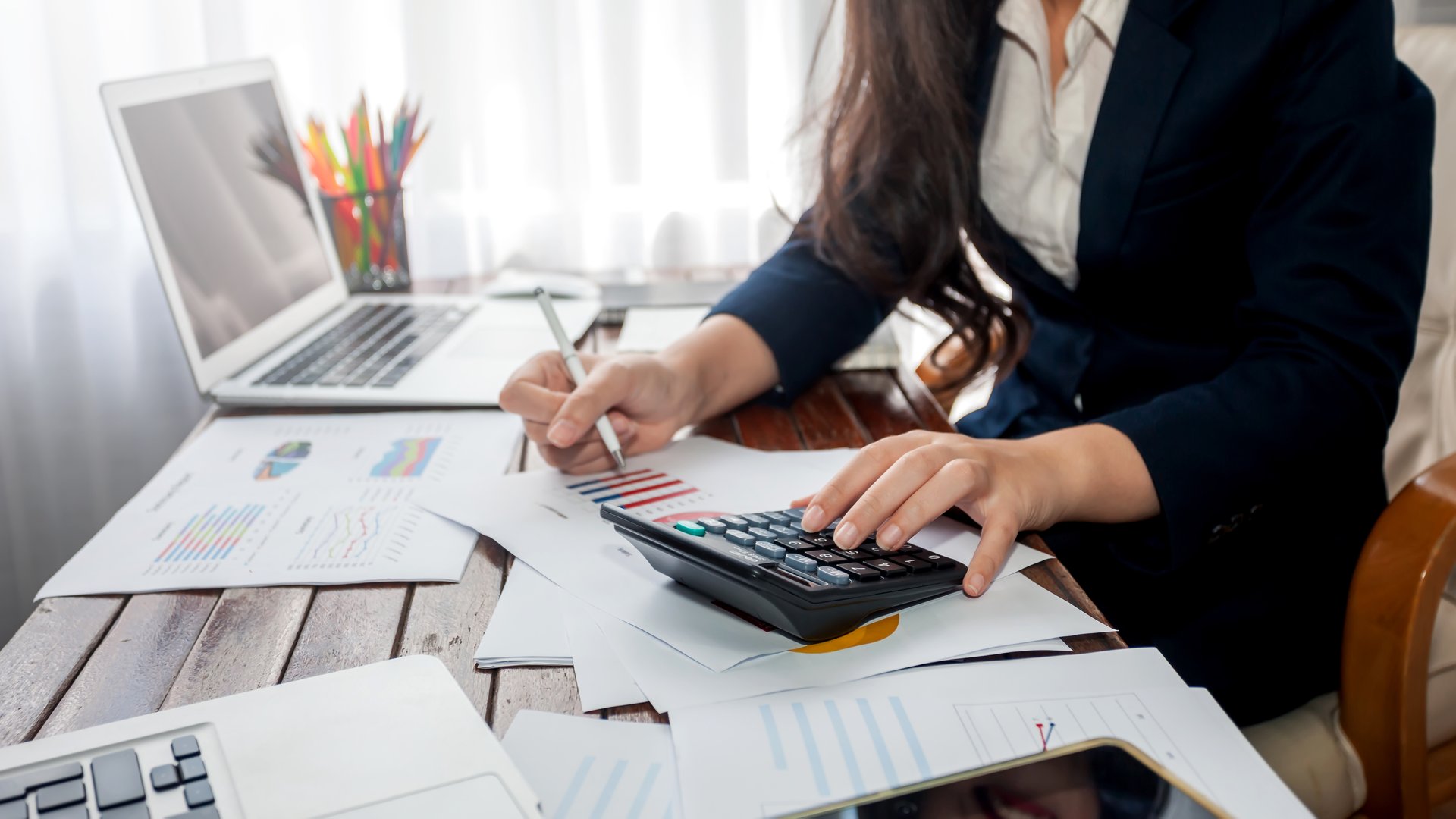 Businesswoman working finance with calculator in office.