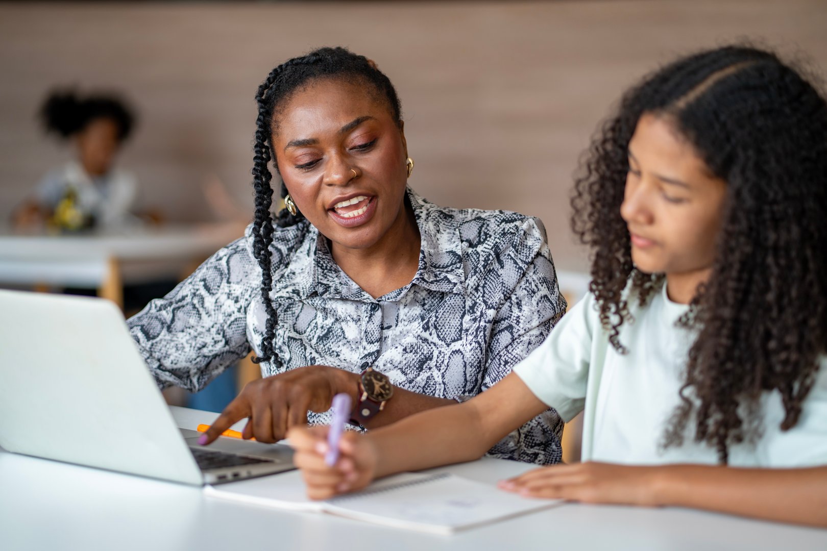 African school teacher is teaching and guiding young student in the class using information from experience and internet for academic literacy study and education usage