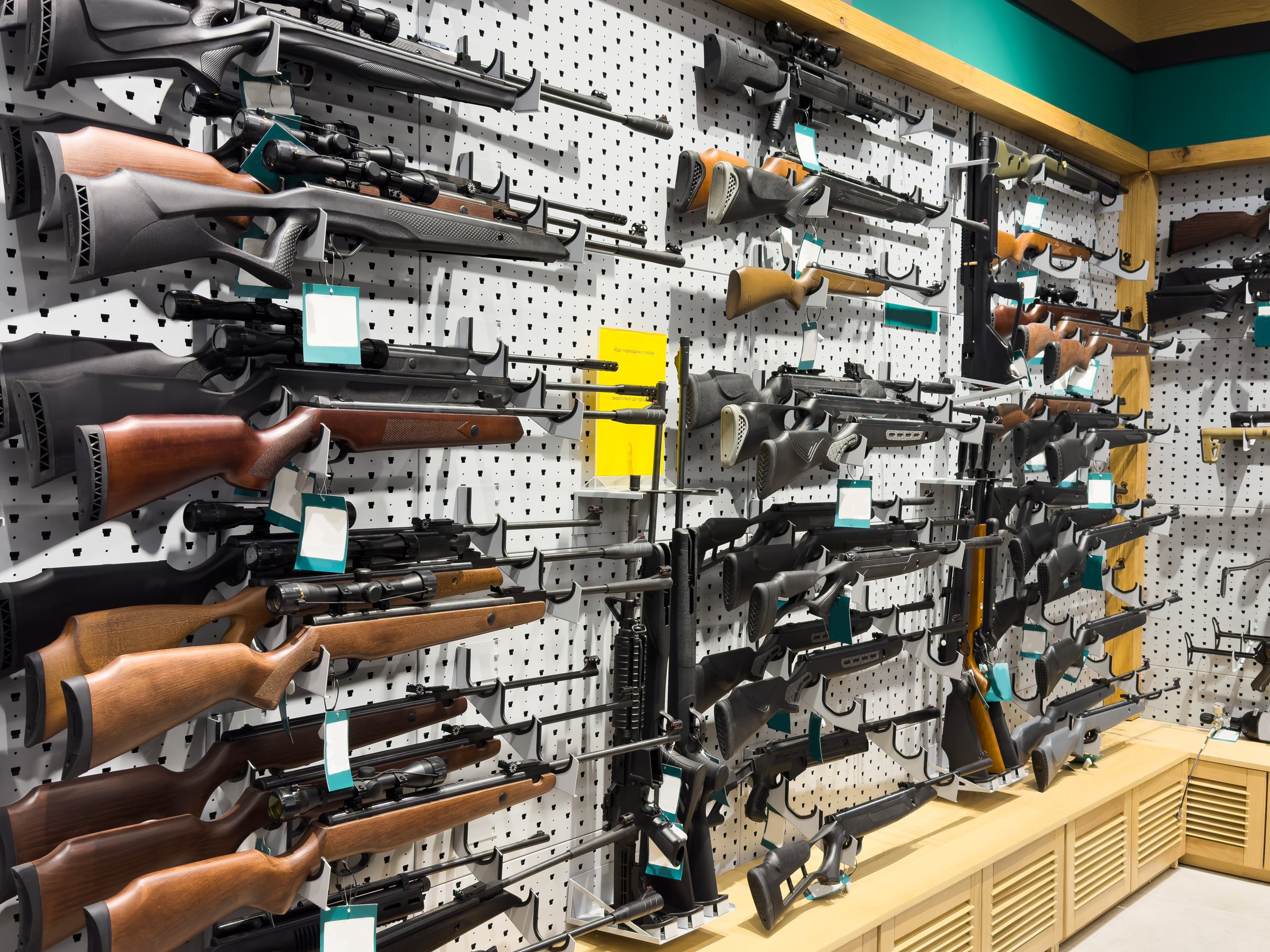 Gun shop interior with various handguns displayed on wall rack. High quality photo