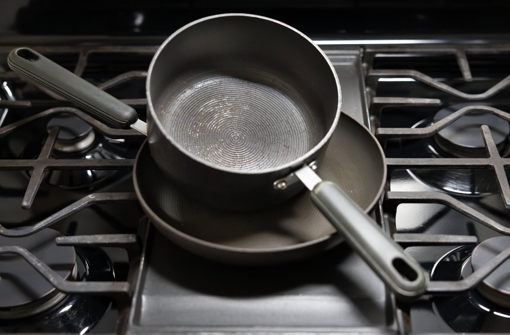 Two teflon coated pans stacked on stovetop