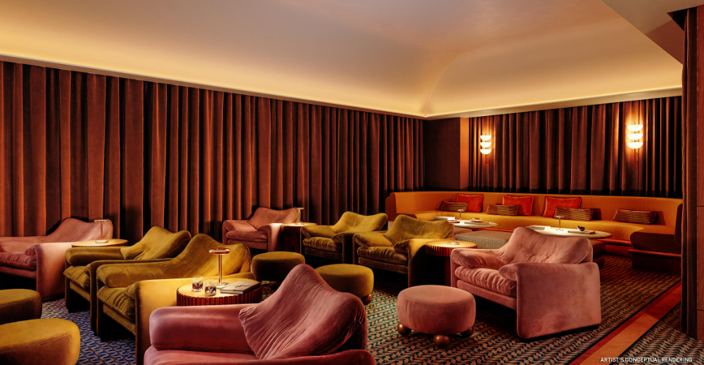 Luxurious cinema lounge with pink velvet chairs, round tables, and ambient lighting, featuring a plush carpet and orange wall panels.