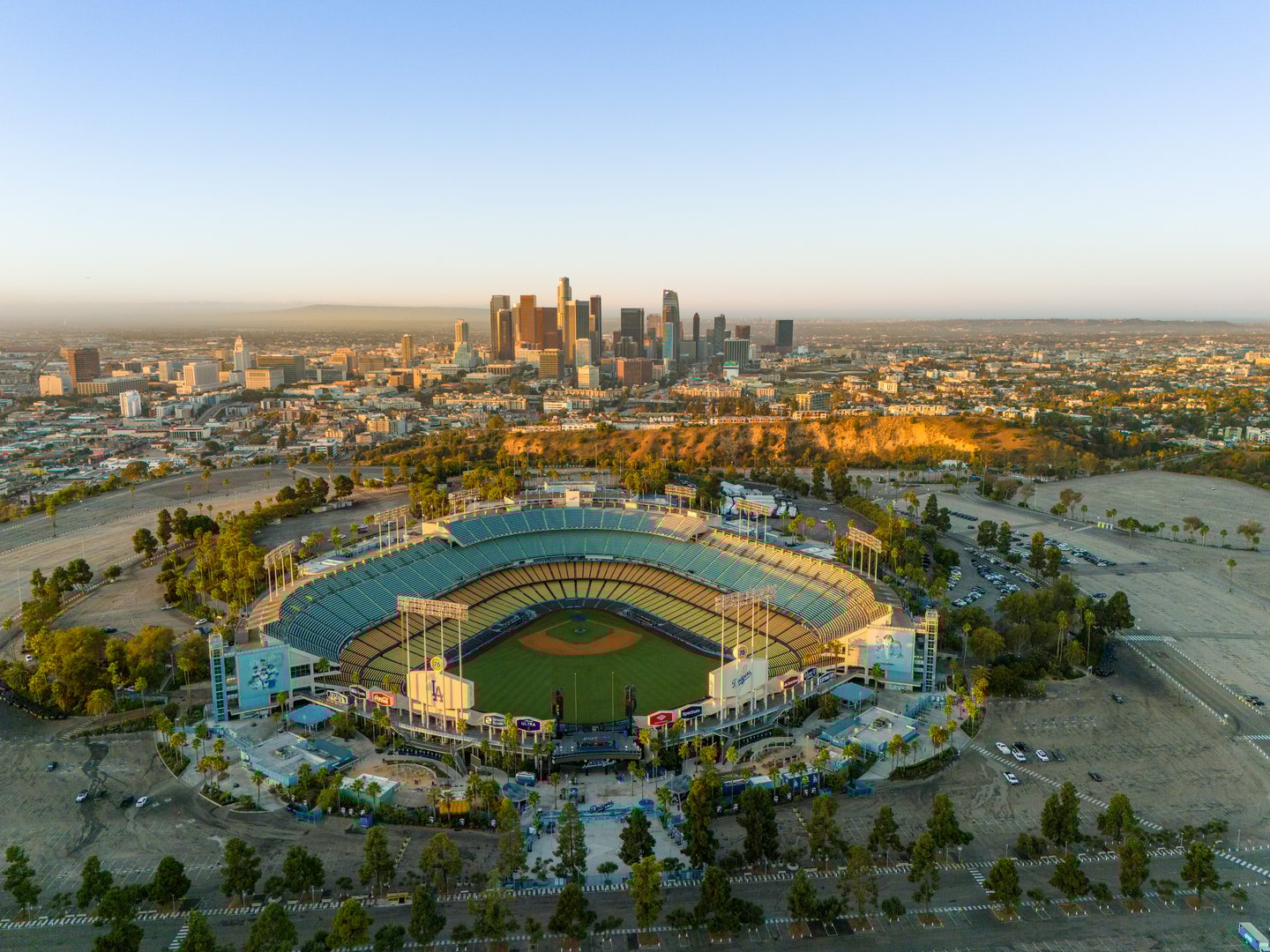 Los Angeles, USA - October 29th 2024: the Dodgers Stadium with the skyline of downtown Los Angeles at dawn. Aerial view, clear sky