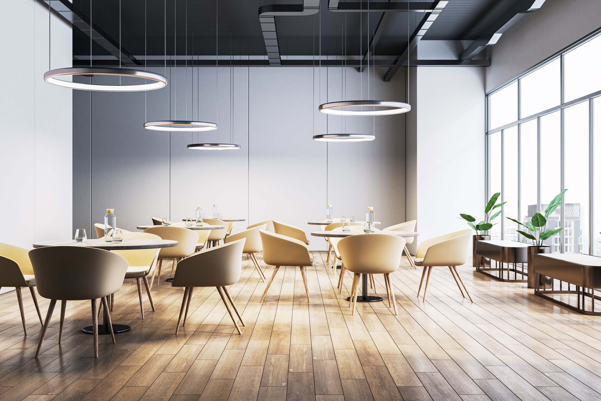 Contemporary cafe interior with wooden flooring, beige chairs, circular hanging lights, and large windows. Bright and modern hospitality concept. 3D Rendering.