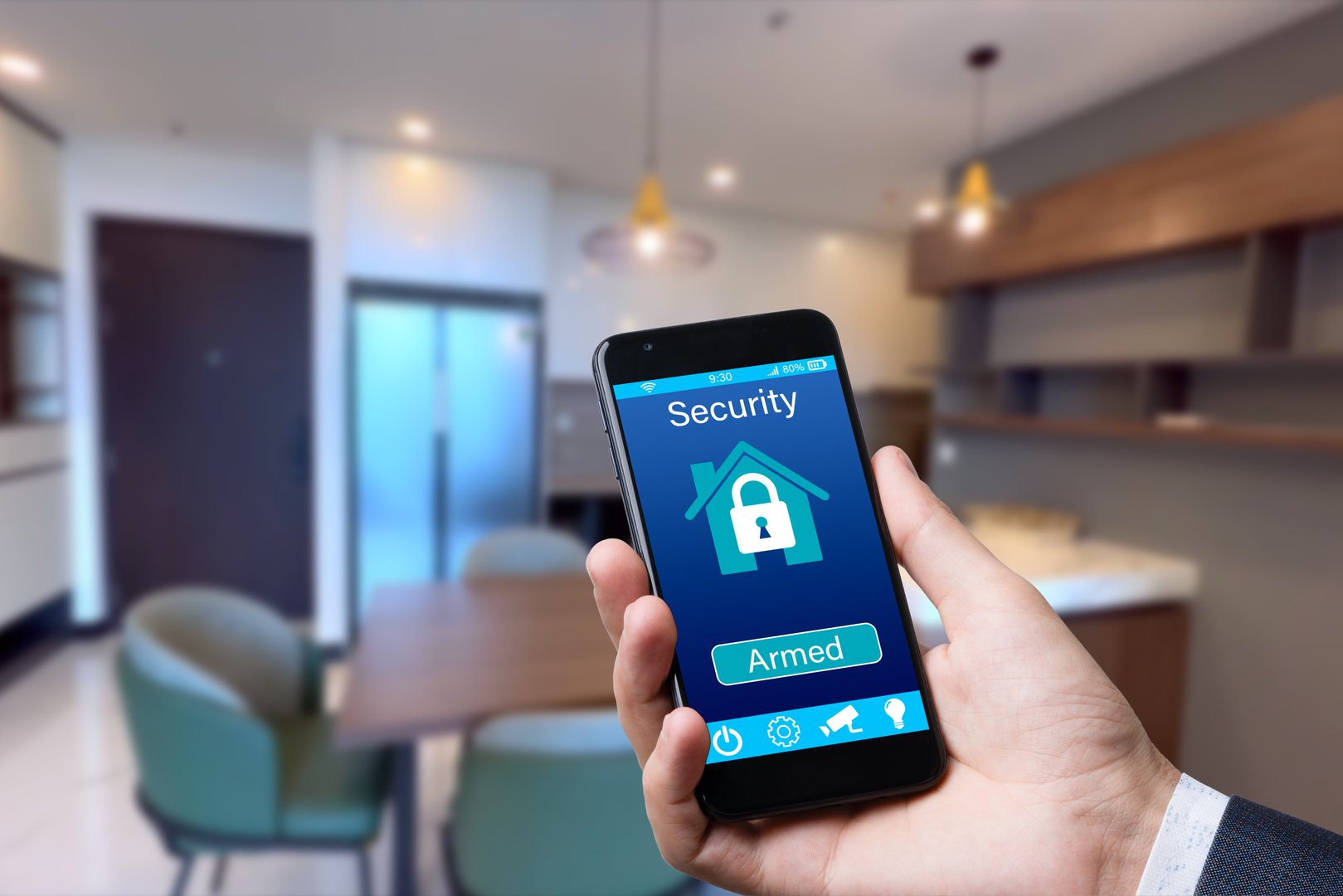 Smart home automation app on smartphone hold by male hand with home interior in background