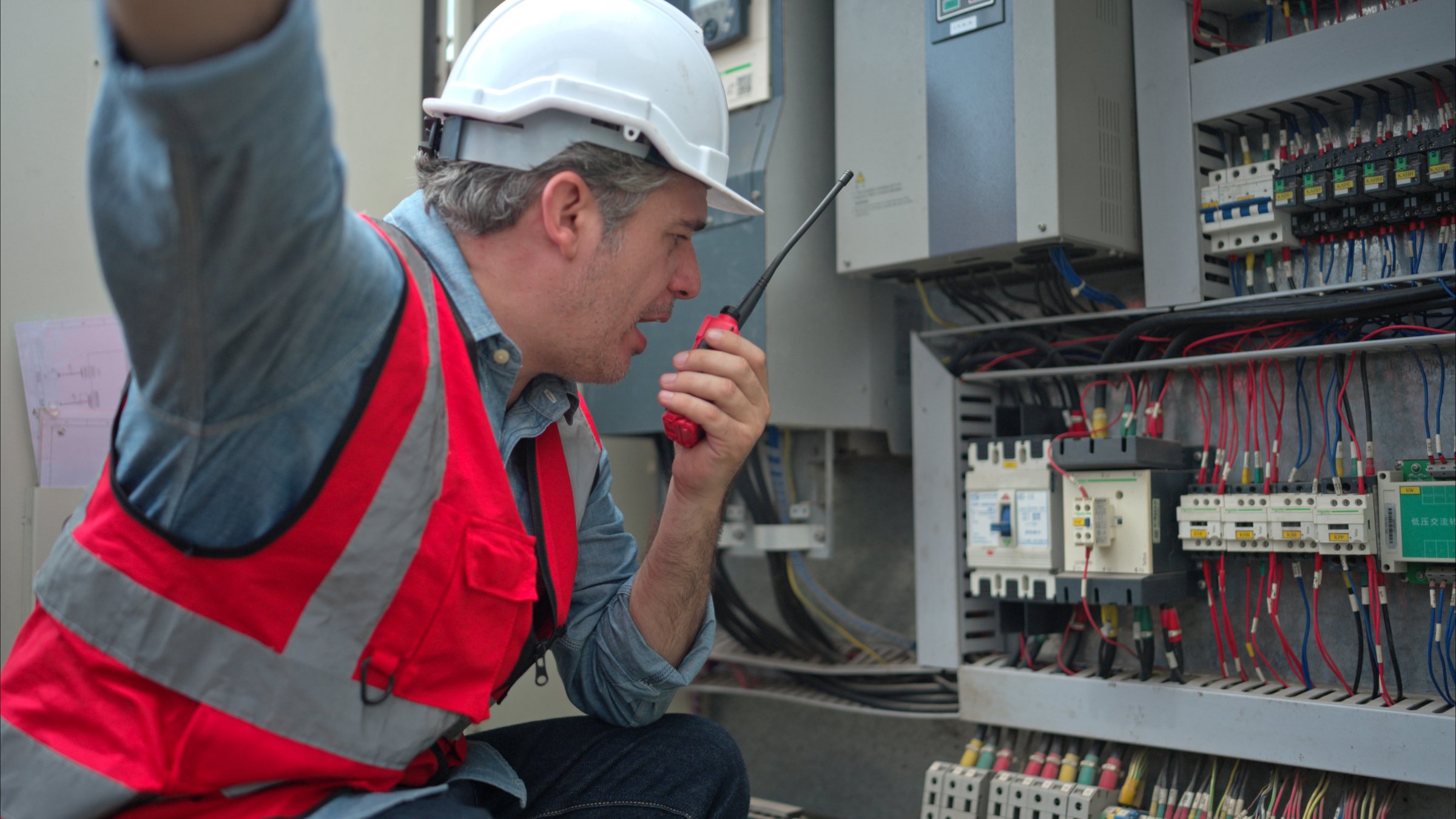 Electrical engineer inspects the electrical control board of a crane before putting it to use on a construction site