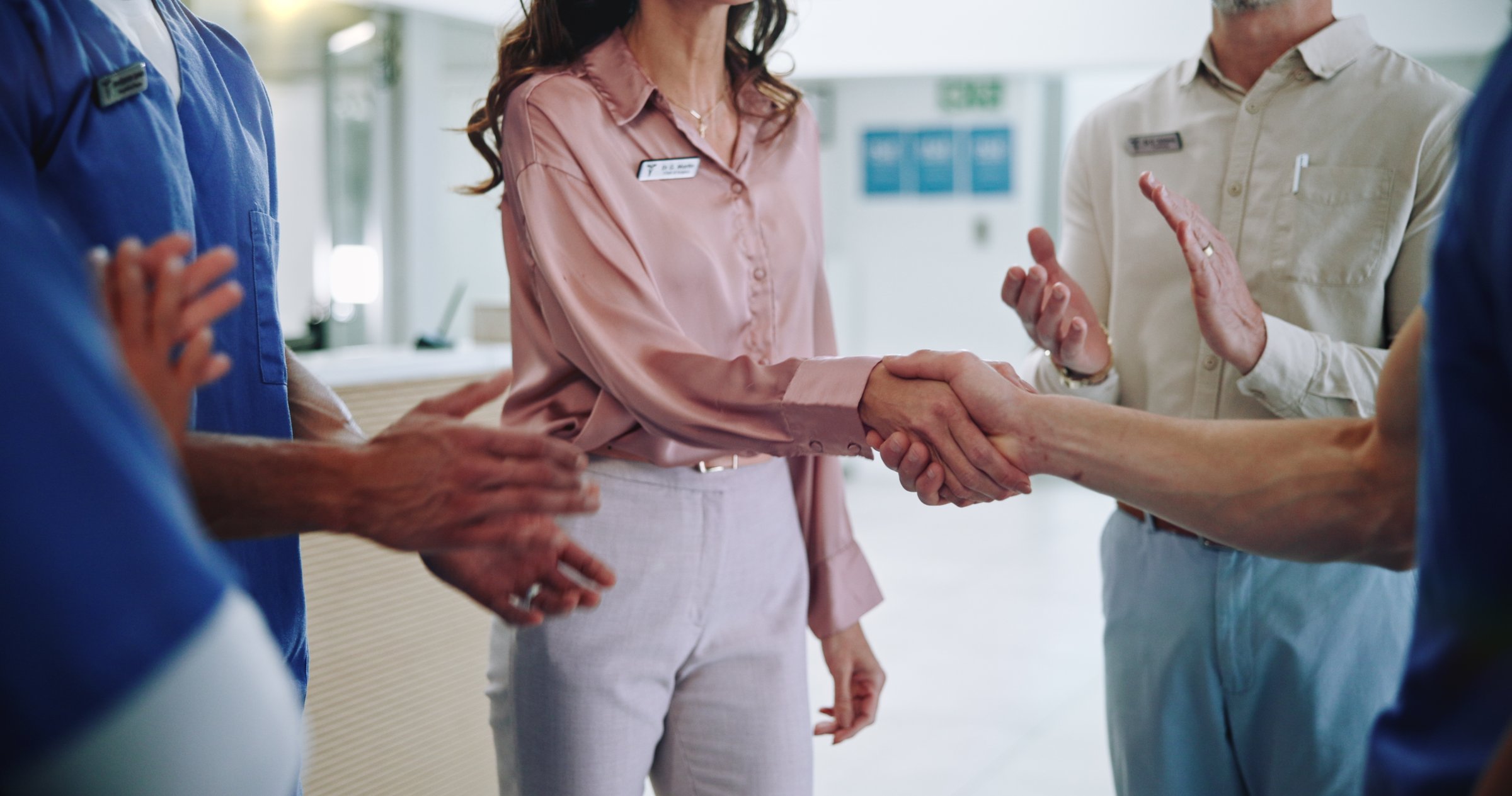 People, doctor or team with applause for handshake, meeting or congratulations together at hospital. Closeup, group or medical employees shaking hands and clapping for winning, hiring or promotion
