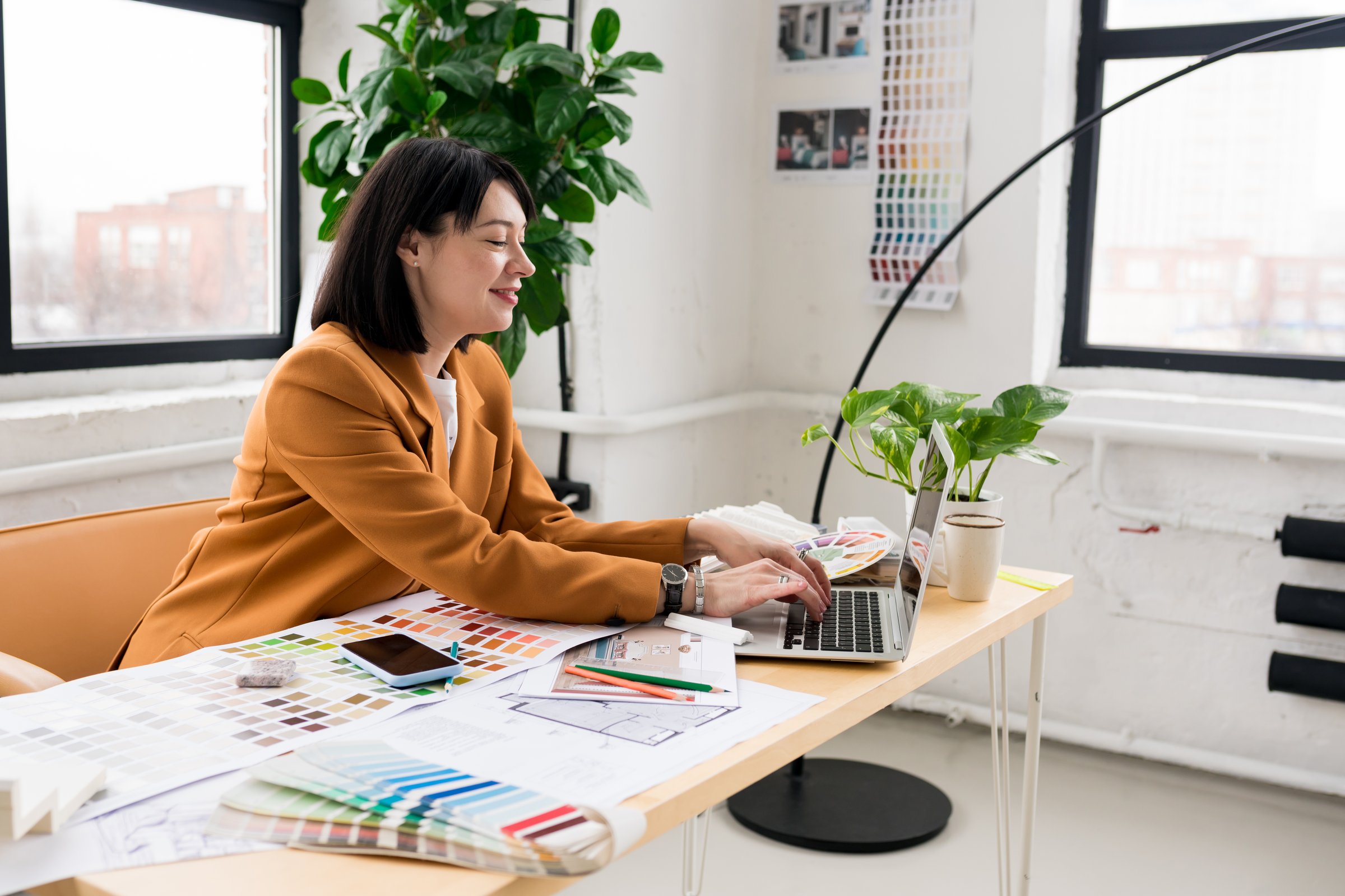 Architecture and interior design concept. Young businesswoman architect choosing materials and details for creating interior design project in studio. Freelancer woman working in a modern office