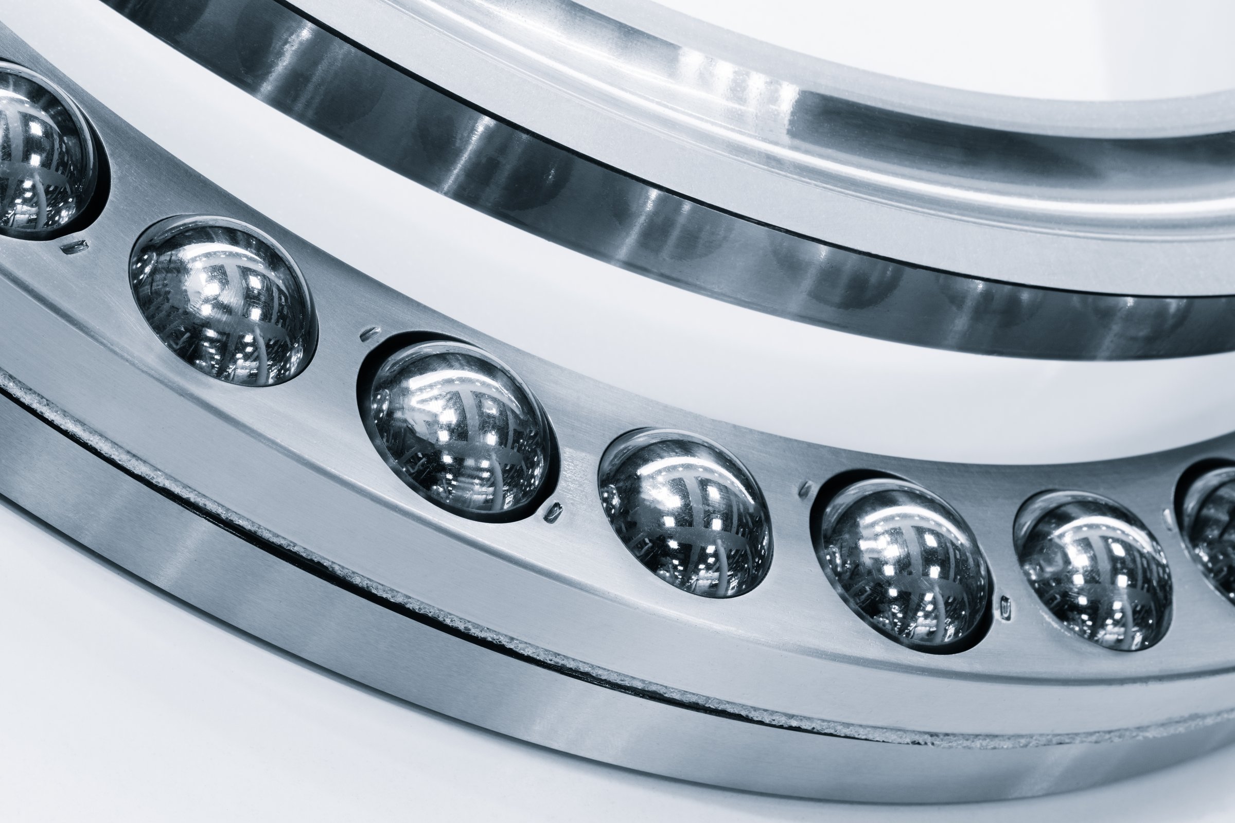 A close up of a ball bearing with a silver rim. Industrial metalworking concept background