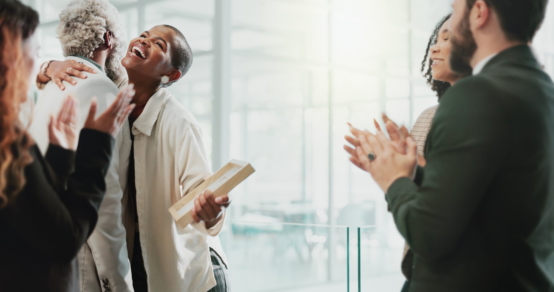 Business people, applause and achievement in office for certificate, celebration and development. Team, clapping and embrace in workplace for congratulations, success and award winner with diversity