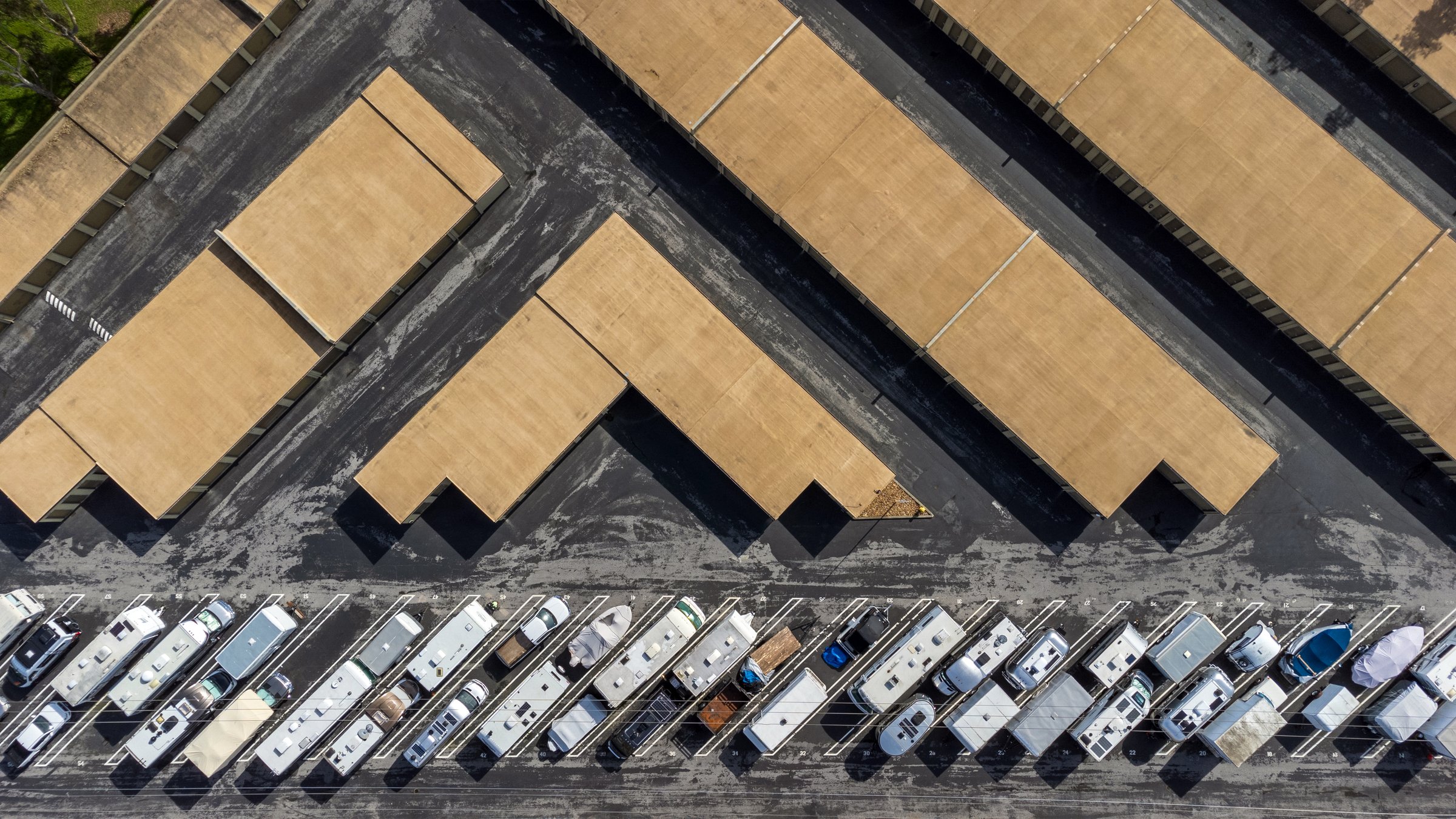 Aerial top down view of a long term self storage facility buildings and outdoor RV, campers and trailers storage.