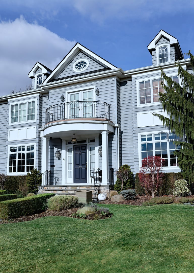 New York State - Dec. 19, 2024: Modern suburban house with gray siding and dormer windows