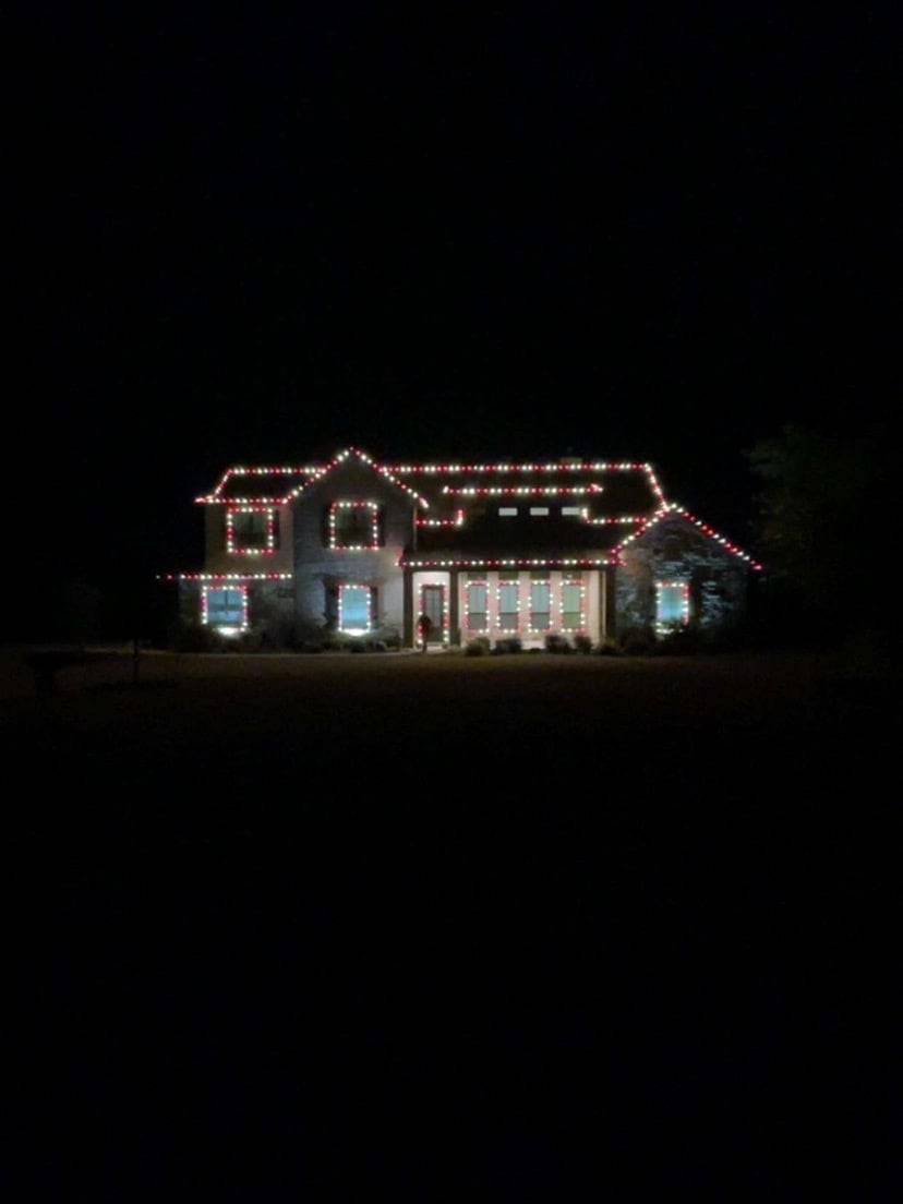 Beautiful Christmas light installation on residential home with roofline and landscaping lighting