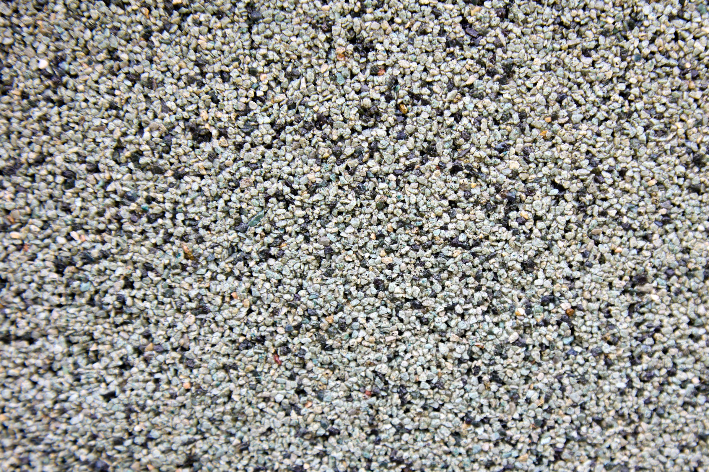 Stone texture of the facade of a modern building. Facade plaster in small crumbs of black and white color. Texture of natural stone for the side surface of the wall of houses