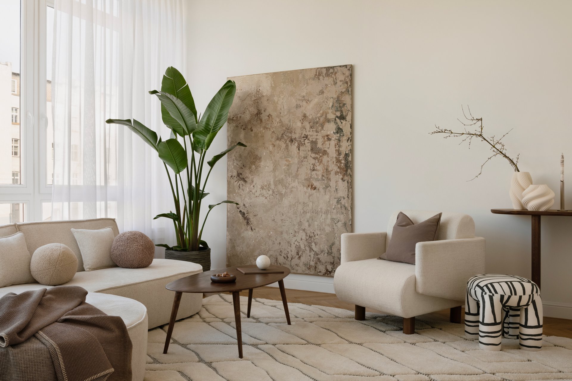 Cozy modern interior with layered textures, sculptural vases, and soft neutral tones.