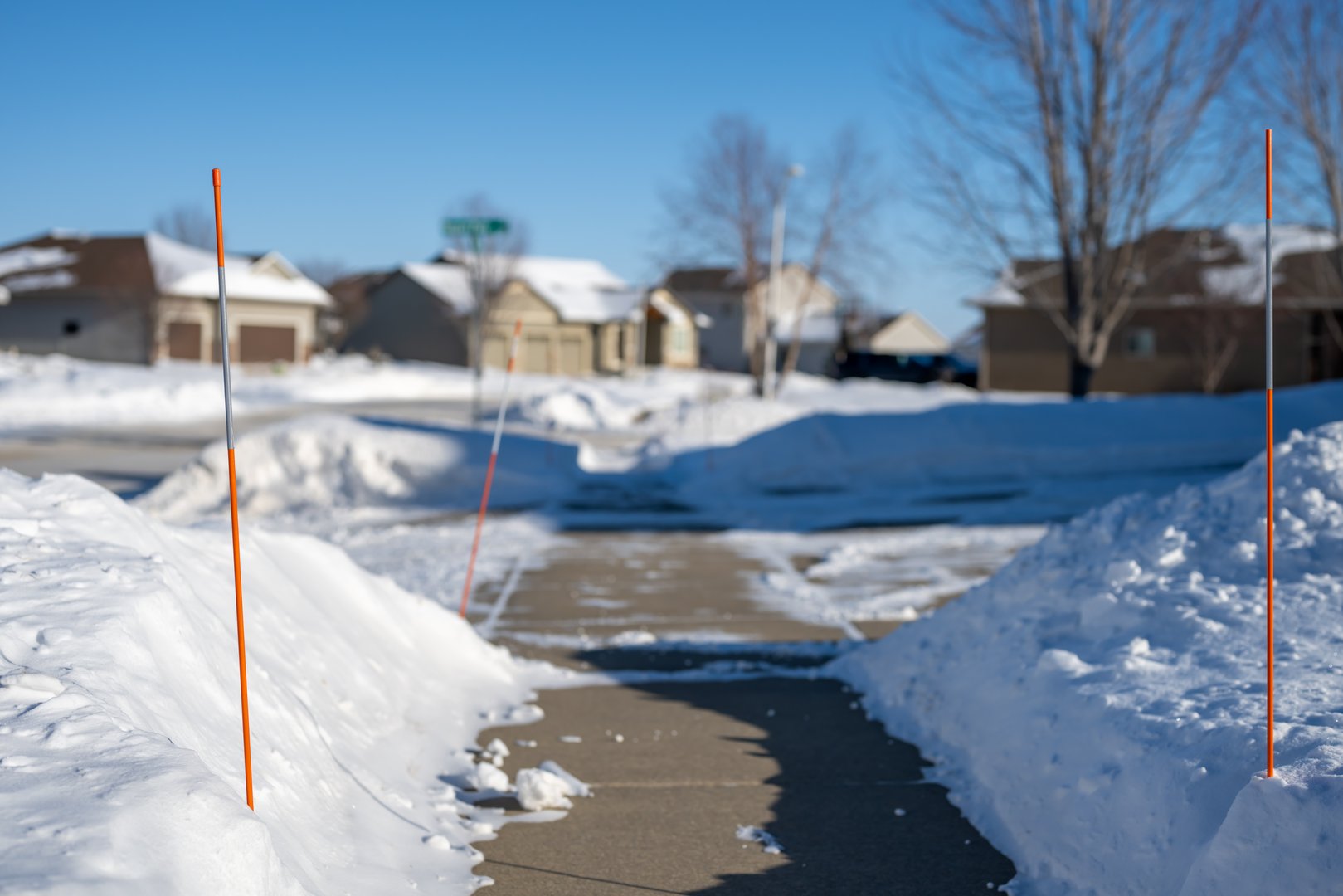 Sidewalk with edge markers used for snow blowing guides. High quality photo