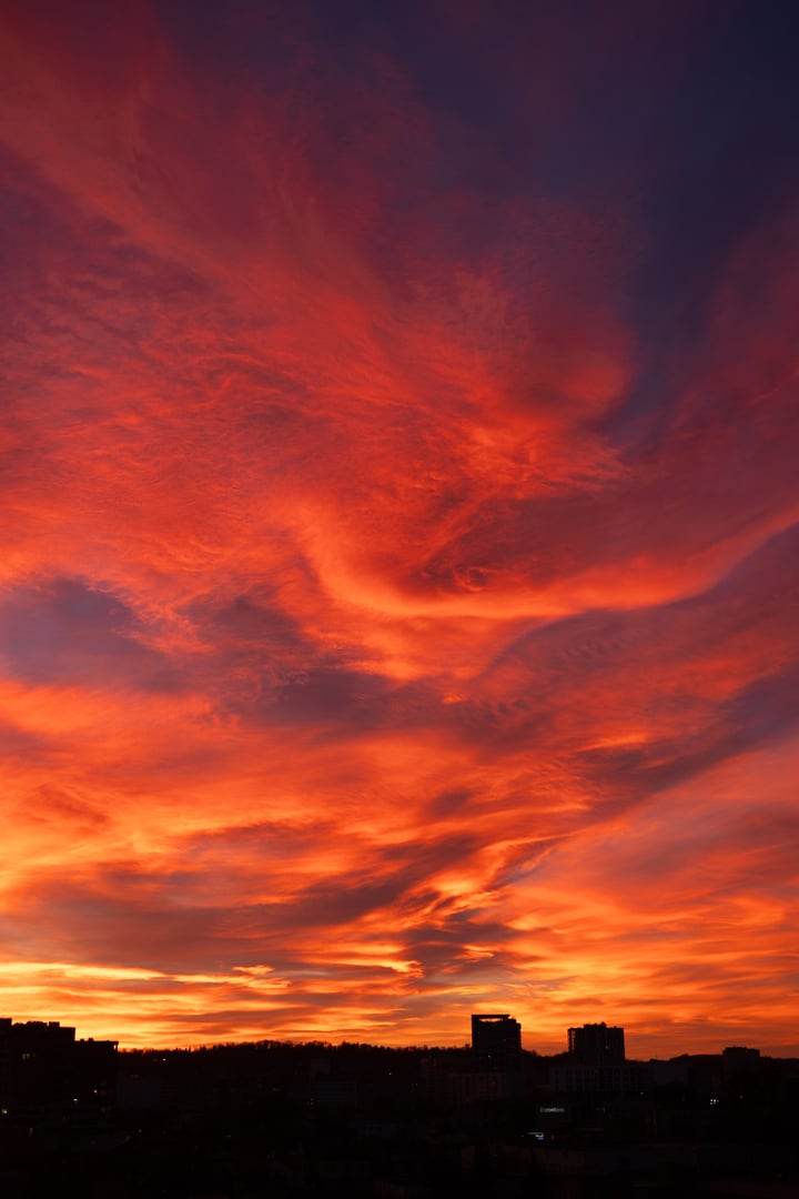 Breathtaking colorful sky at sunset with silhouettes of houses