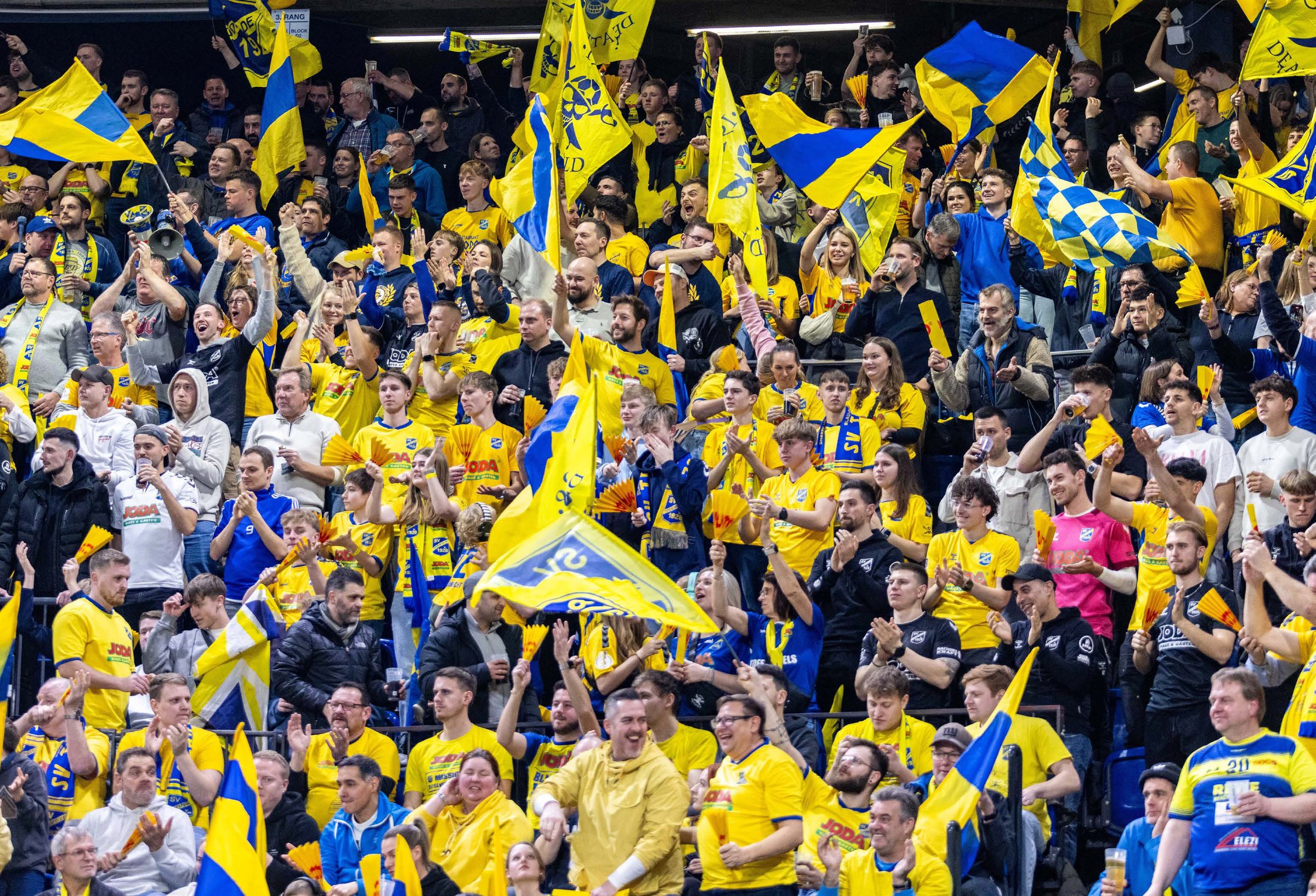 SV Todesfelde Fanblock mit blau-gelben Fahnen im JODA-Sportpark - Regionalliga Holstein Fußball