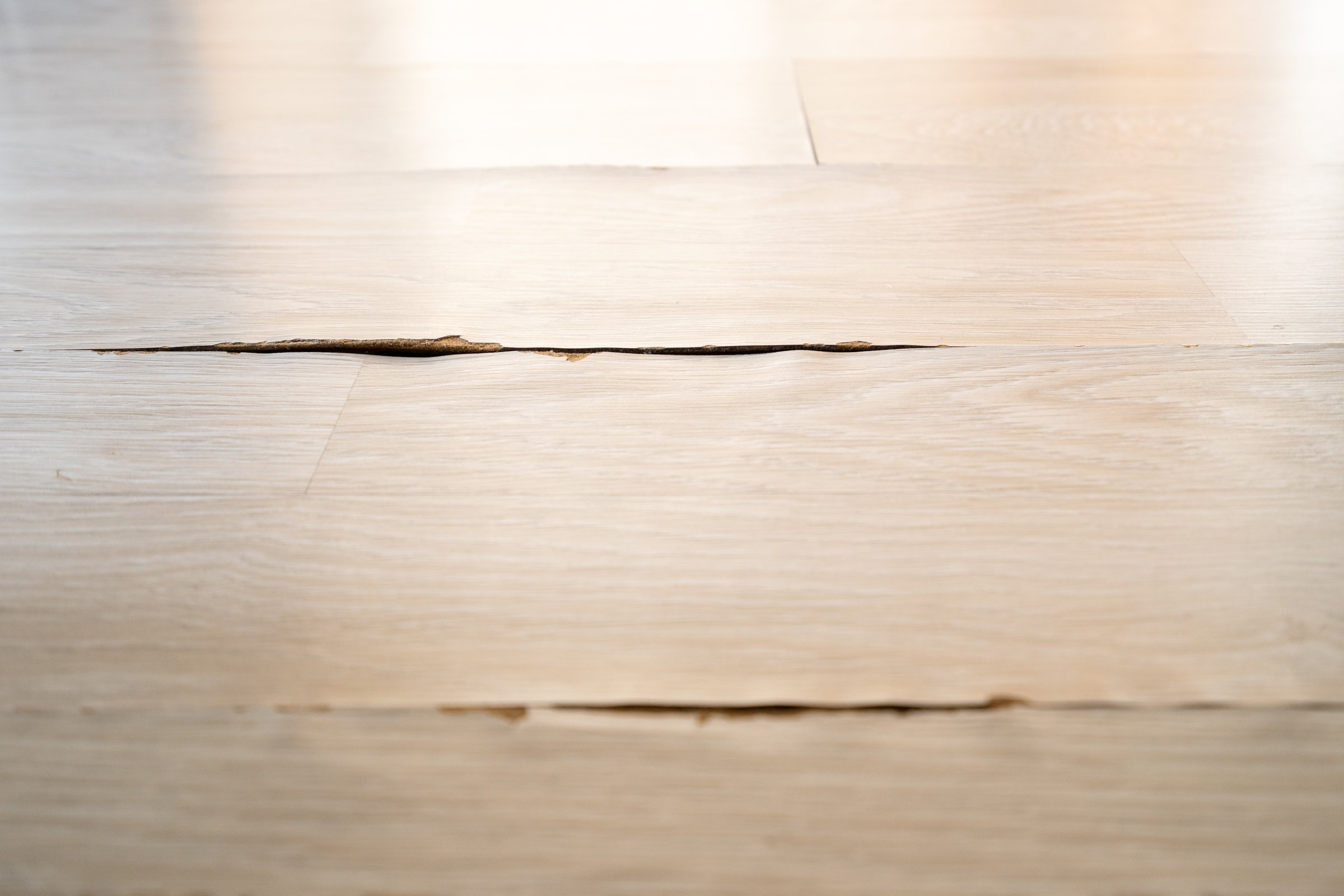 Destroyed laminate floor, flat lay. Top view of cracks and damage on floorboards reveal the pressing need for restoration in apartment. Concepts of renovation and interior improvement effort.