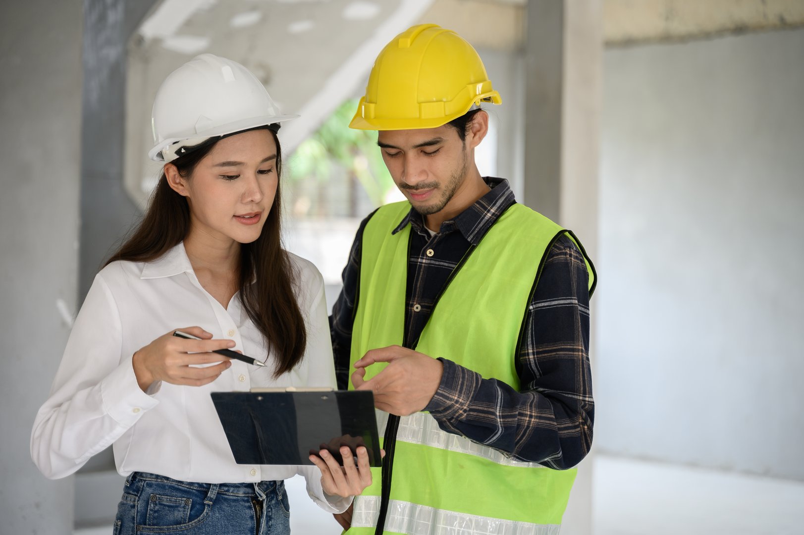 Female civil engineer consulting with construction site foreman