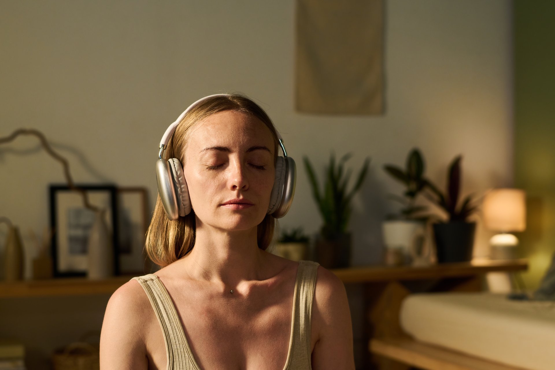 Žena koja praktikuje samohipnozu i opuštanje sa slušalicama - audio vježbe za smirenost i transformaciju uma