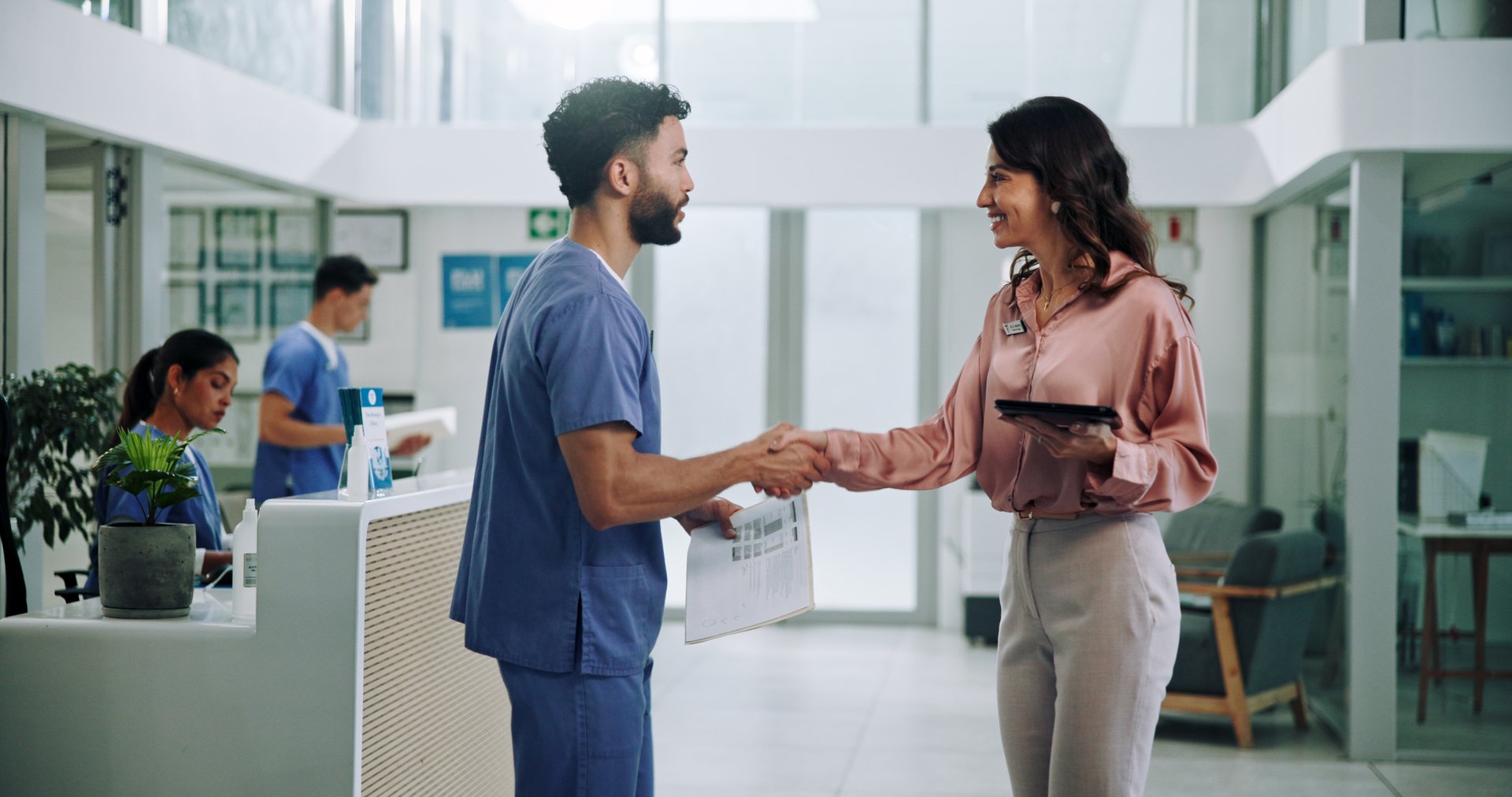 Doctor, meeting and tablet with handshake for contract, agreement or hiring nurse at hospital. Man, woman or medical colleagues shaking hands for recruitment, deal or teamwork together at clinic