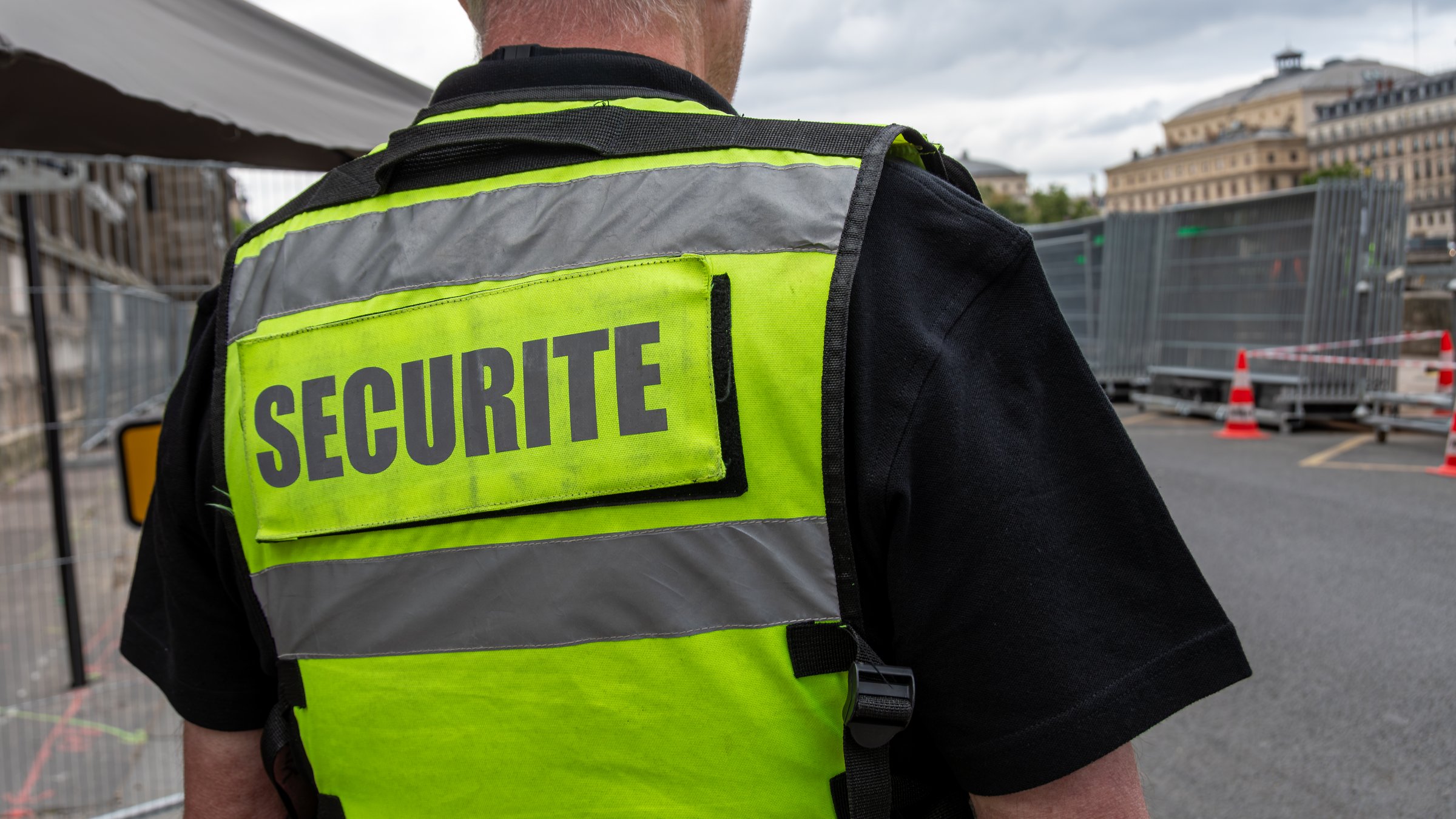 Paris, France - July 10, 2024: Close-up of a fluorescent yellow vest with the word "security" (securite) written in French worn by a private security guard watching a secure site