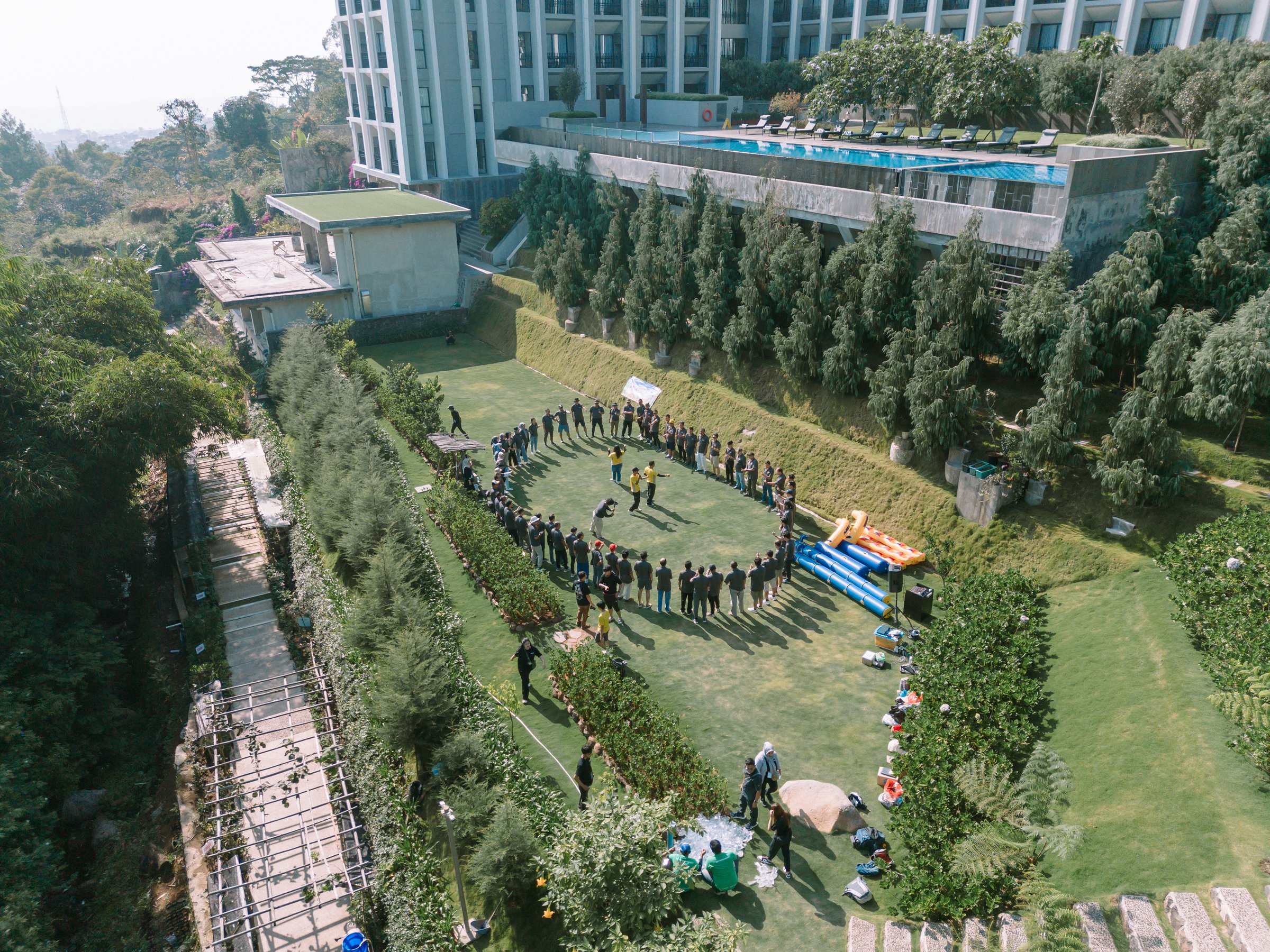 Bogor, September, 19 2024. A group of people engaged in team building activities at an outdoor hotel venue. Ideal for themes of teamwork, collaboration, and corporate retreats.