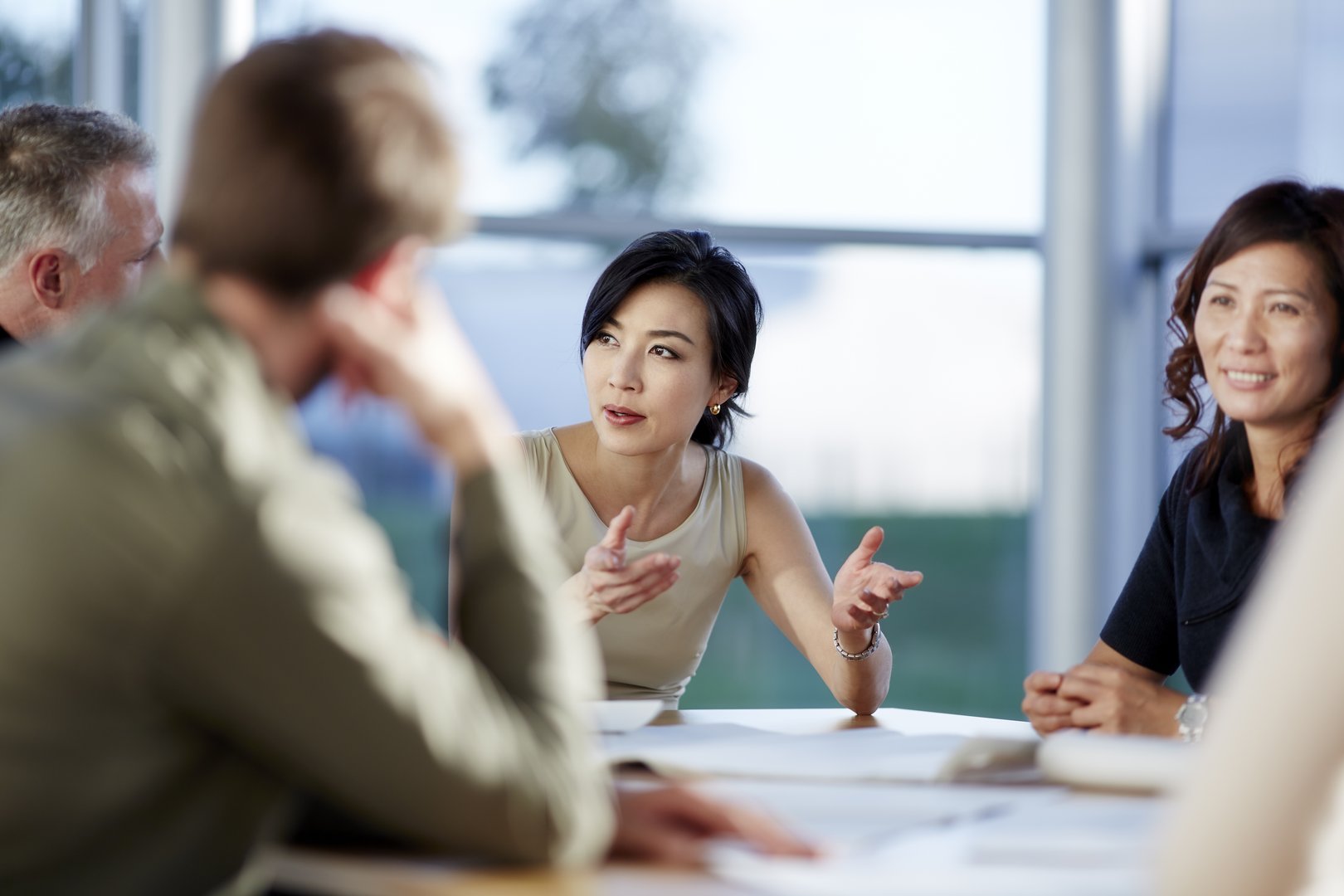 Business meeting with diverse group of professionals seated around a table discussing and exchanging ideas