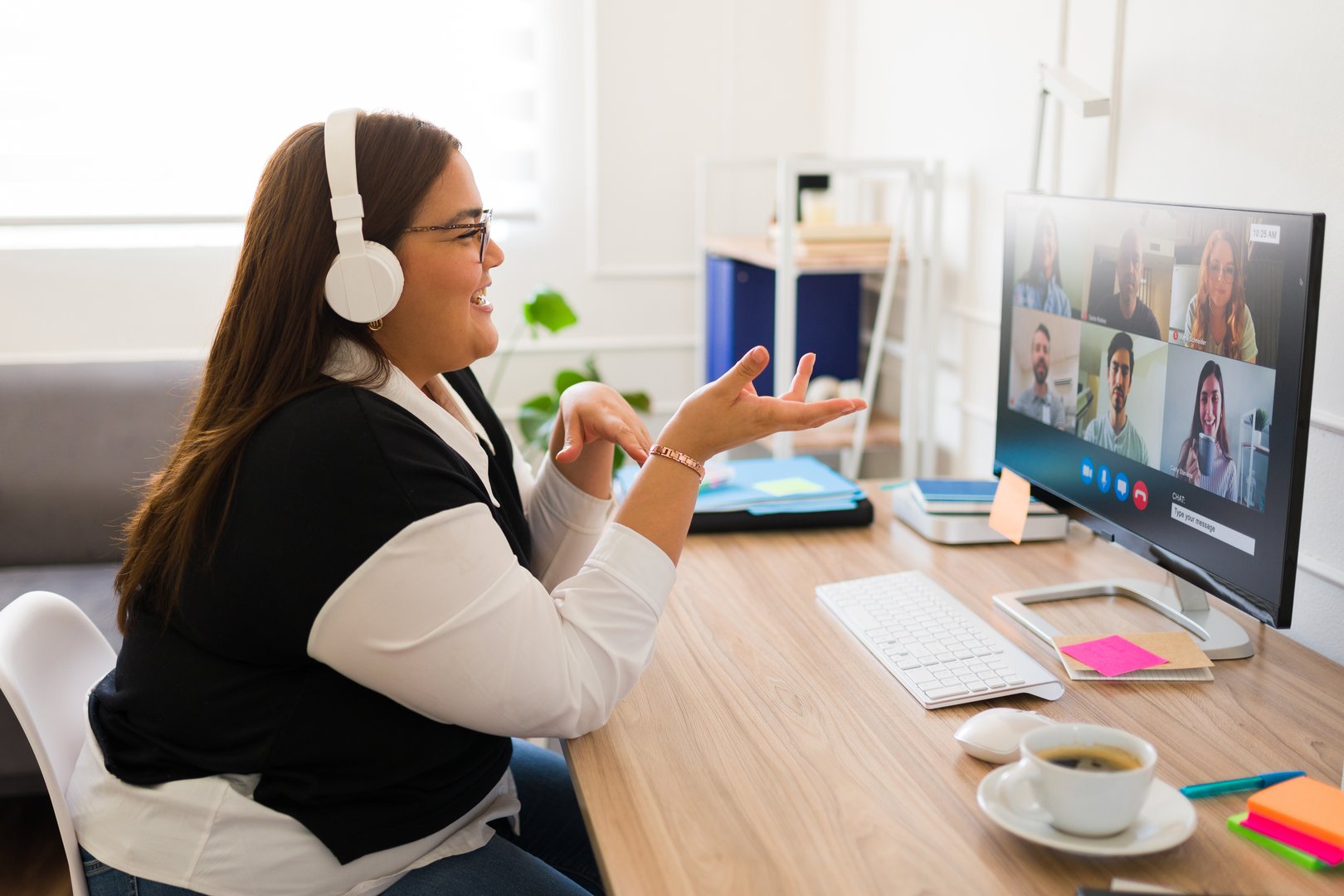 Professional big woman with headphones talking about her business and work during an online video call