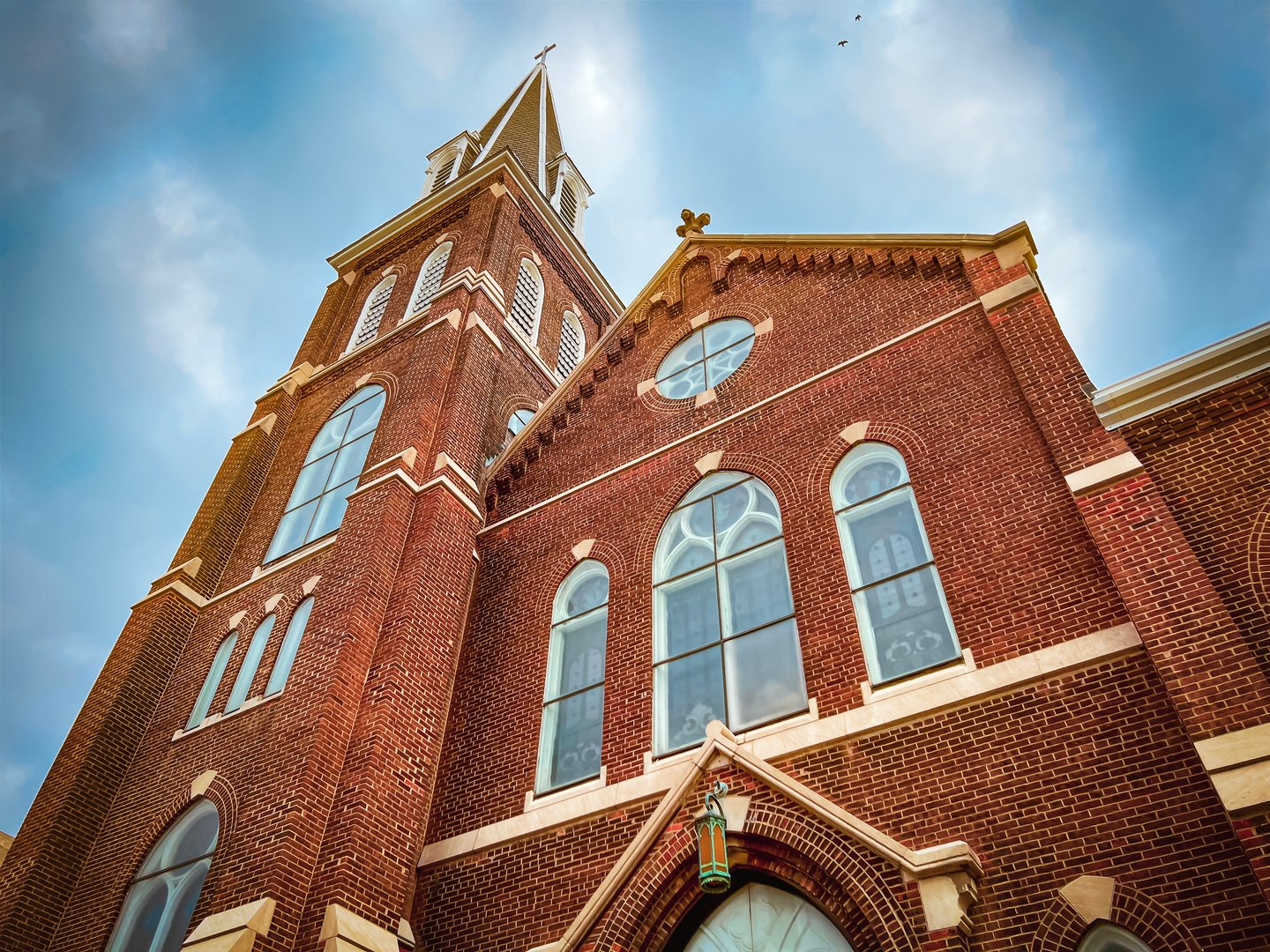 A majestic ornate old church stands tall against a dramatic blue sky. Ornate architectural details and stained glass windows. Set in the downtown historical district in Springfield, Illinois, USA.