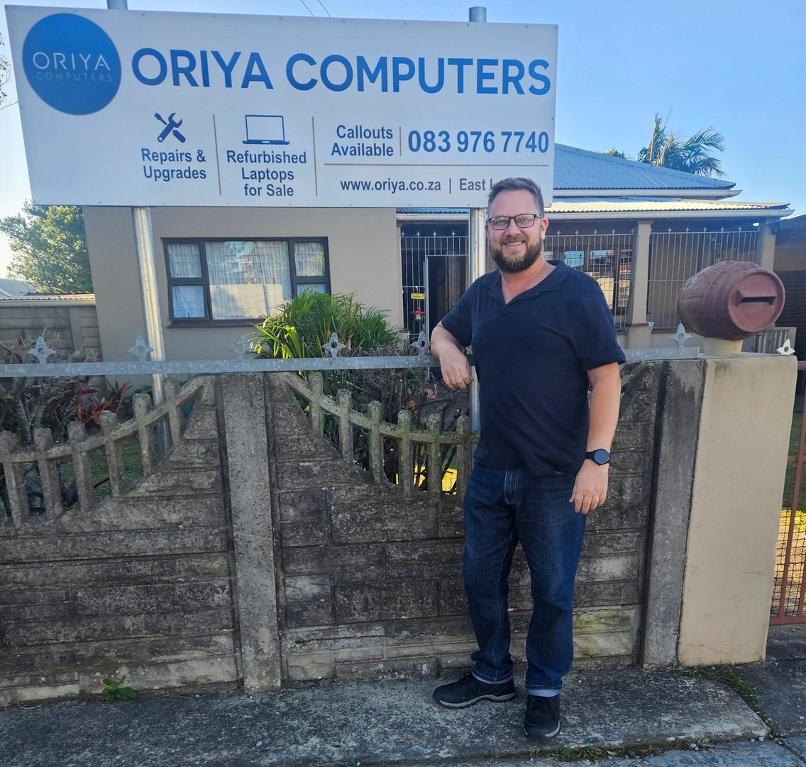 Owner in front of new Oriya Computers business sign