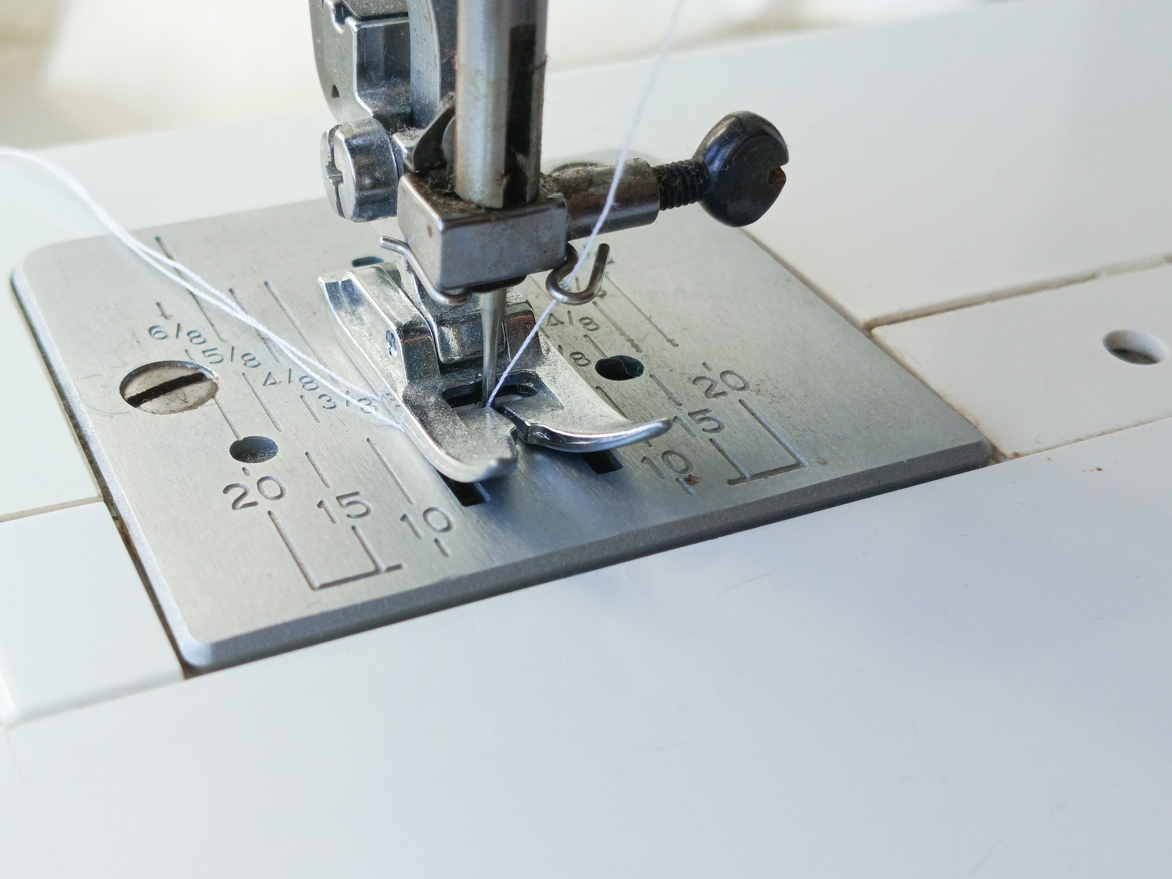 Sewing machine foot close-up. Atelier. Advertising background, space for text. Sewing production of clothes concept.