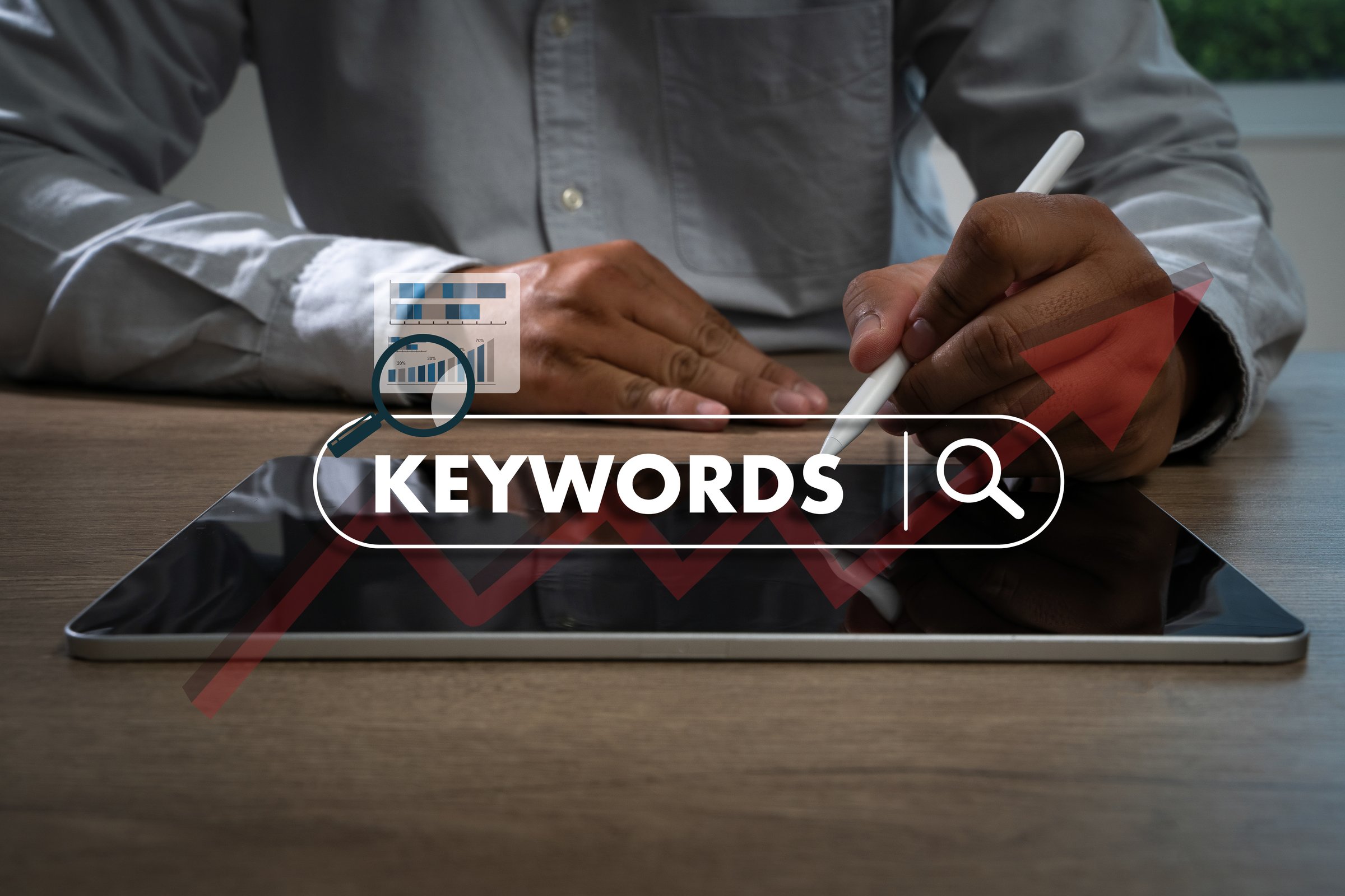 keywords on laptop browse in office optimize seo engine man is using a tablet to type the word "keywords"
