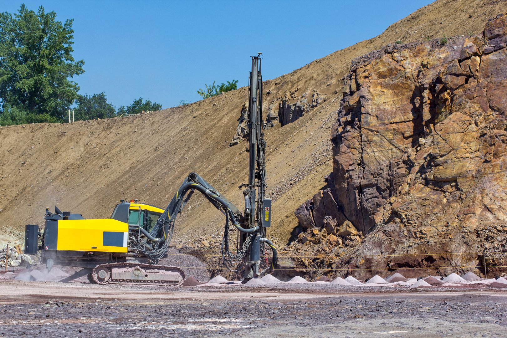 The Vertical drilling rig machine in stone quarry. Drilling Tractor Working in the Mine. Mining Quarry, Mine. Equipment for heavy-mining industry.