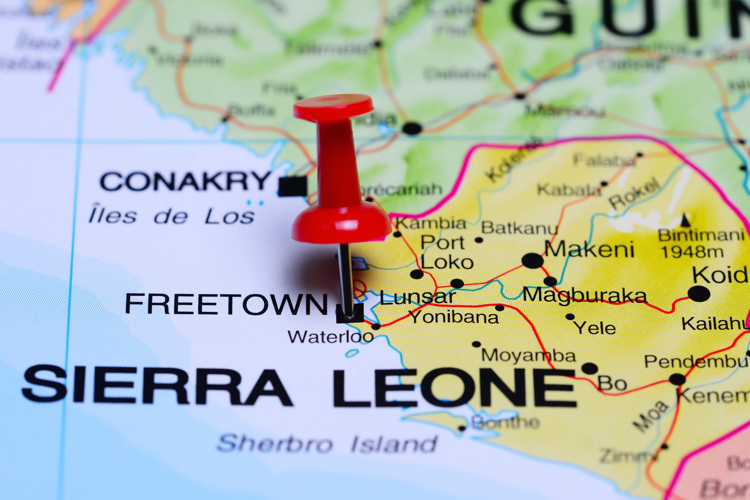 Photo of pinned Freetown on a map of Africa. May be used as illustration for traveling theme.