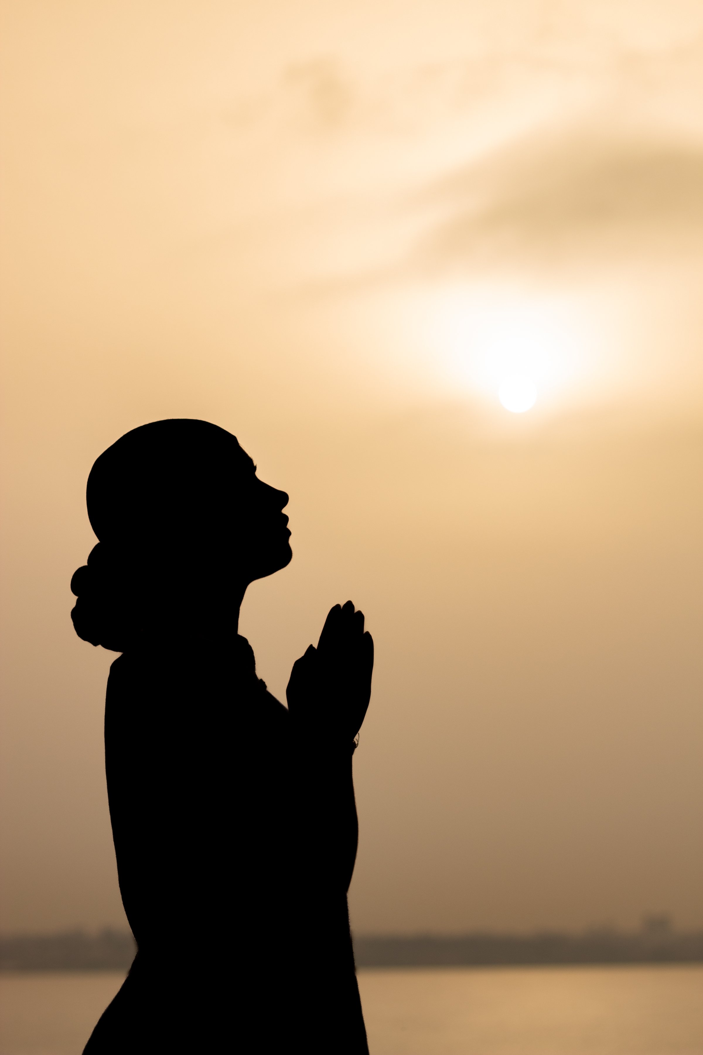 Woman praying at sunrise