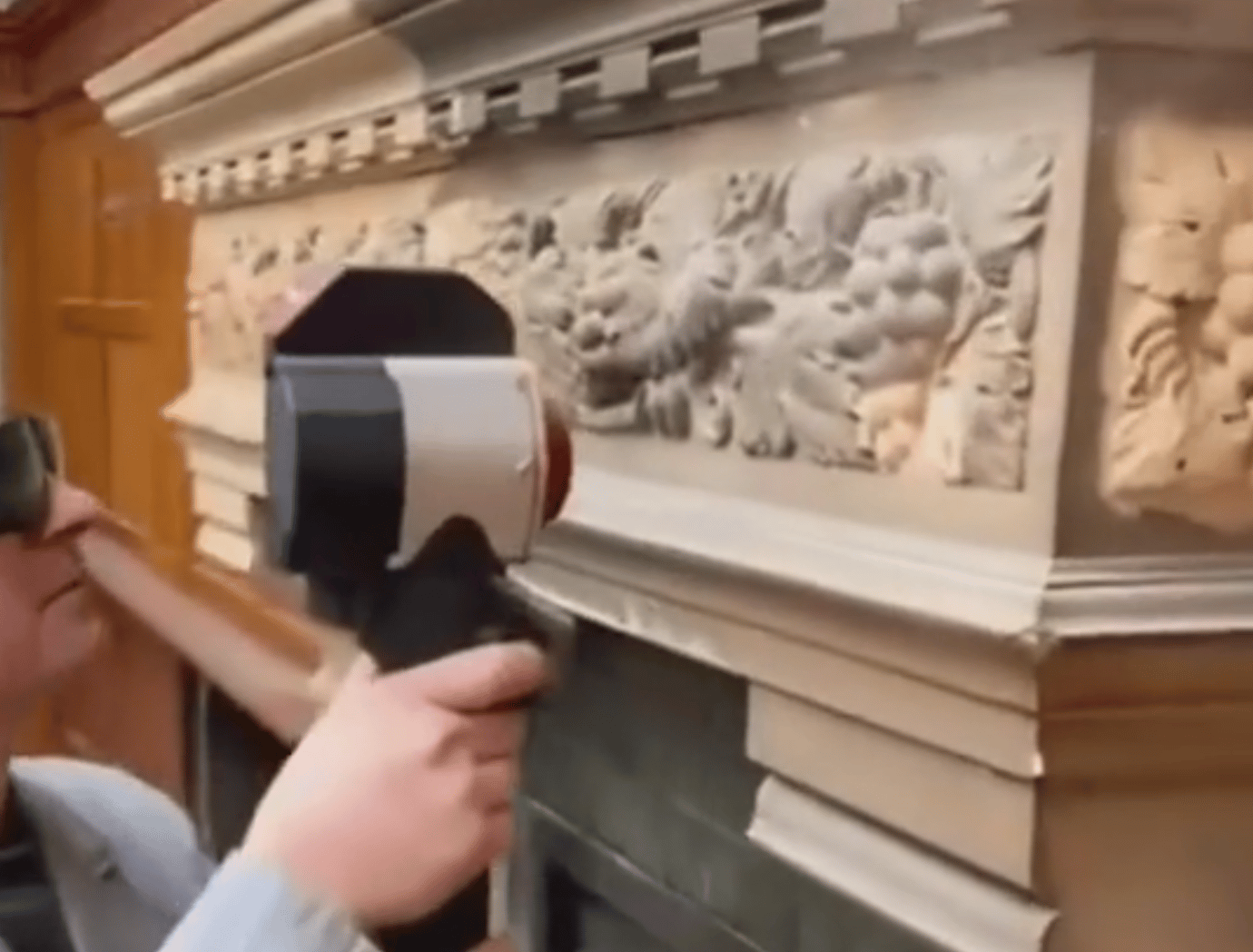 A man works with an electric grinder to clean rust from metal iron structures. Rust removal using an electric iron brush. Hands in work gloves are holding a power tool.