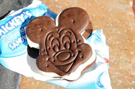 Ice cream sandwich shaped like a cartoon character's head, with chocolate cookies and vanilla ice cream, on packaging.