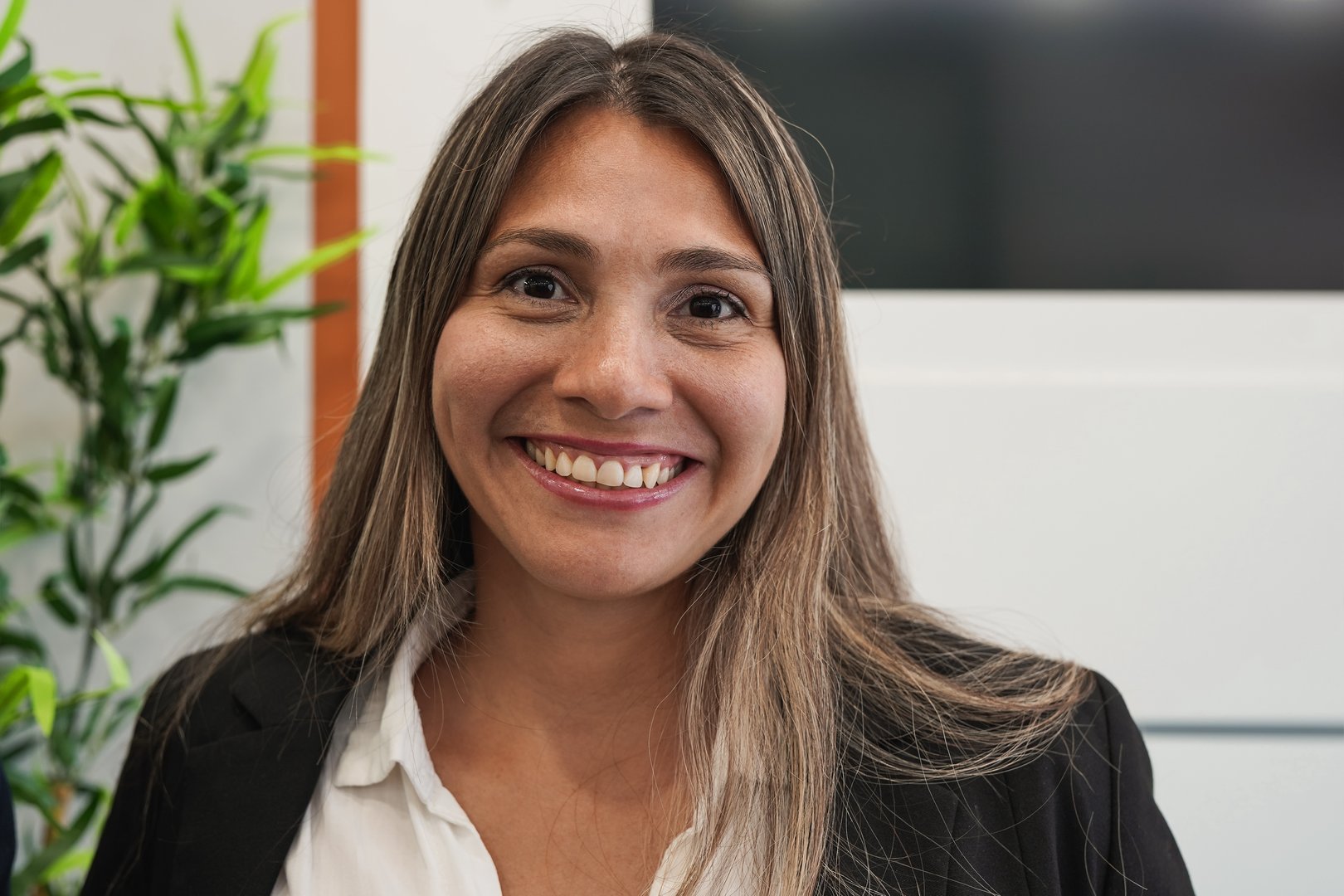 Young business woman looking on camera inside modern office