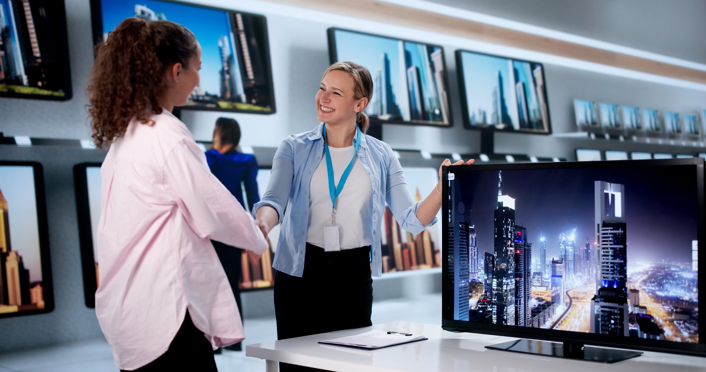Expert Latina Saleswoman Helps Young Lady Choose Smart TV Model