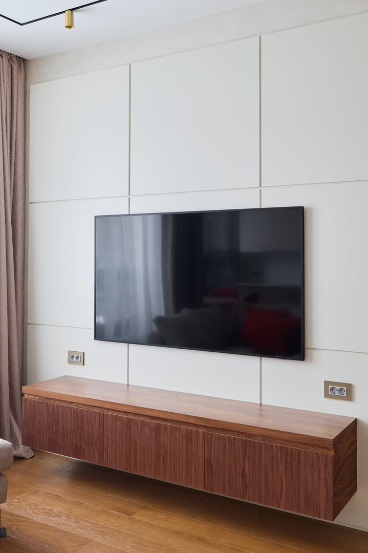 A stylish and sleek interior design that showcases a mounted television paired with a sophisticated storage unit